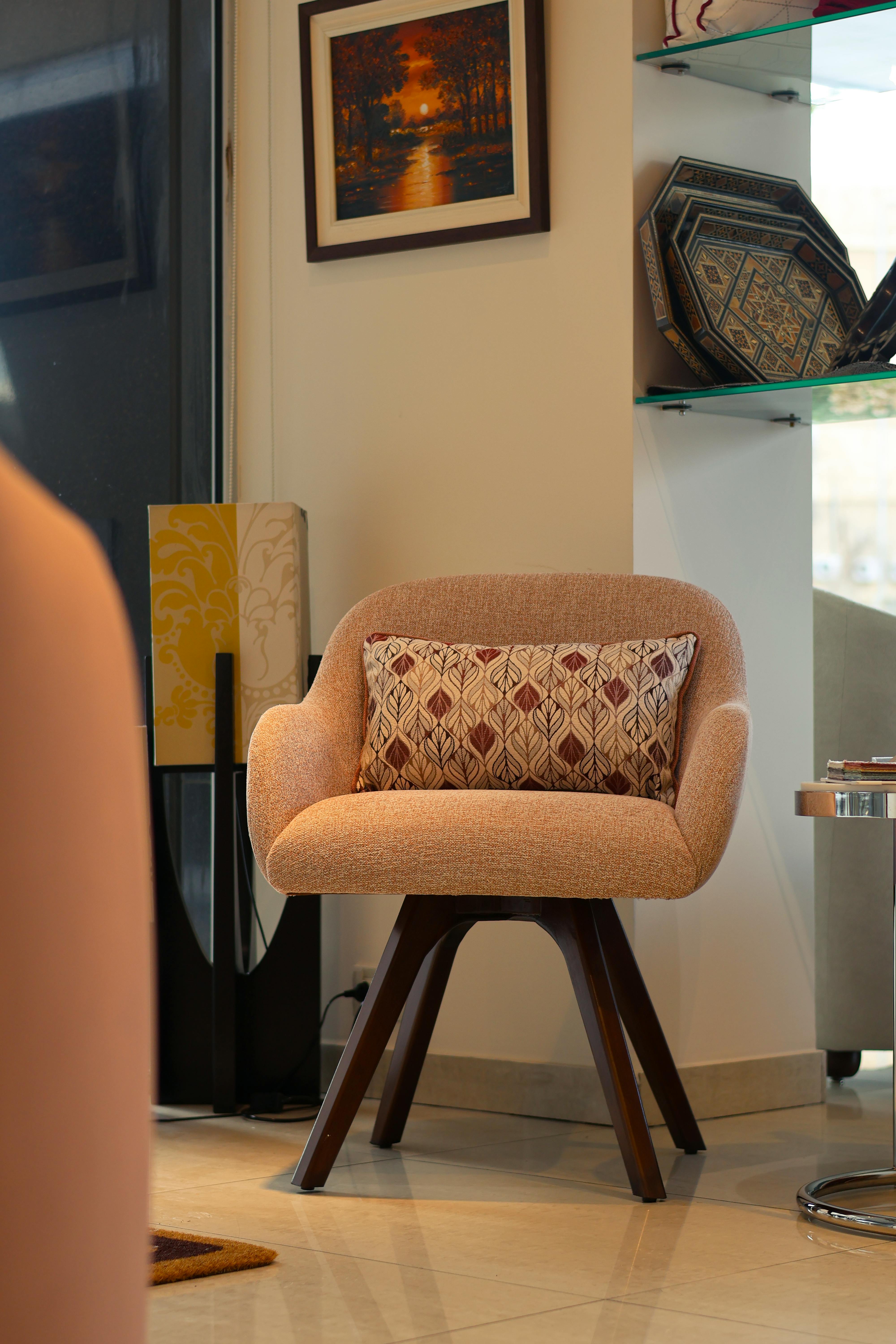 무료 세련된 핑크색 쿠션 의자가 현대적인 실내 거실에 놓여 있습니다. 스톡 사진