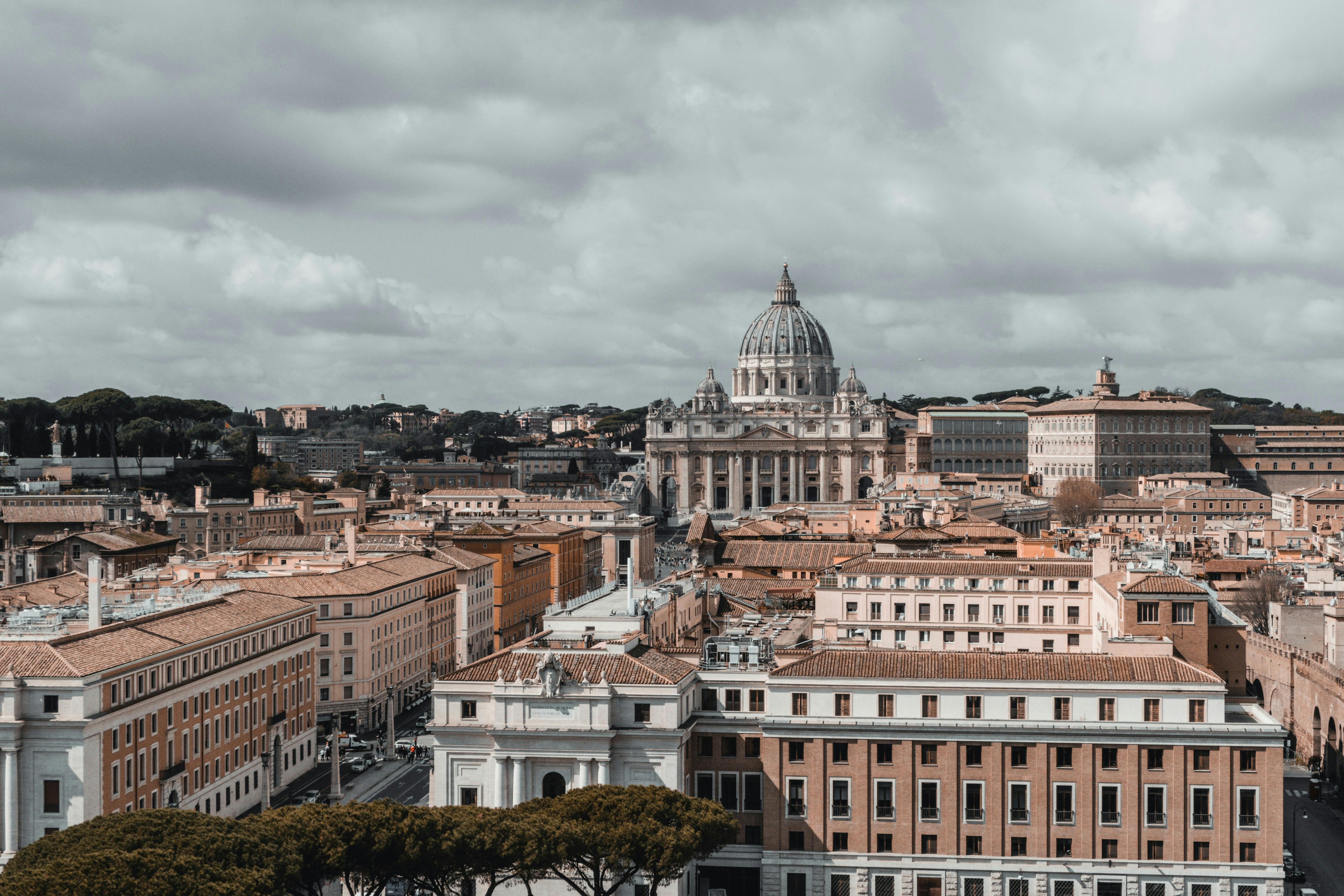 Gratis Vista panorámica de la Ciudad del Vaticano, con la Basílica de San Pedro bajo un cielo nublado. Foto de stock