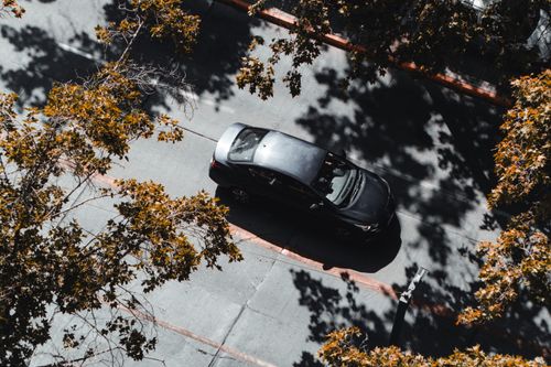 Free Captured from above, a car navigates a tree-lined street in Santiago, Chile, during fall. Stock Photo