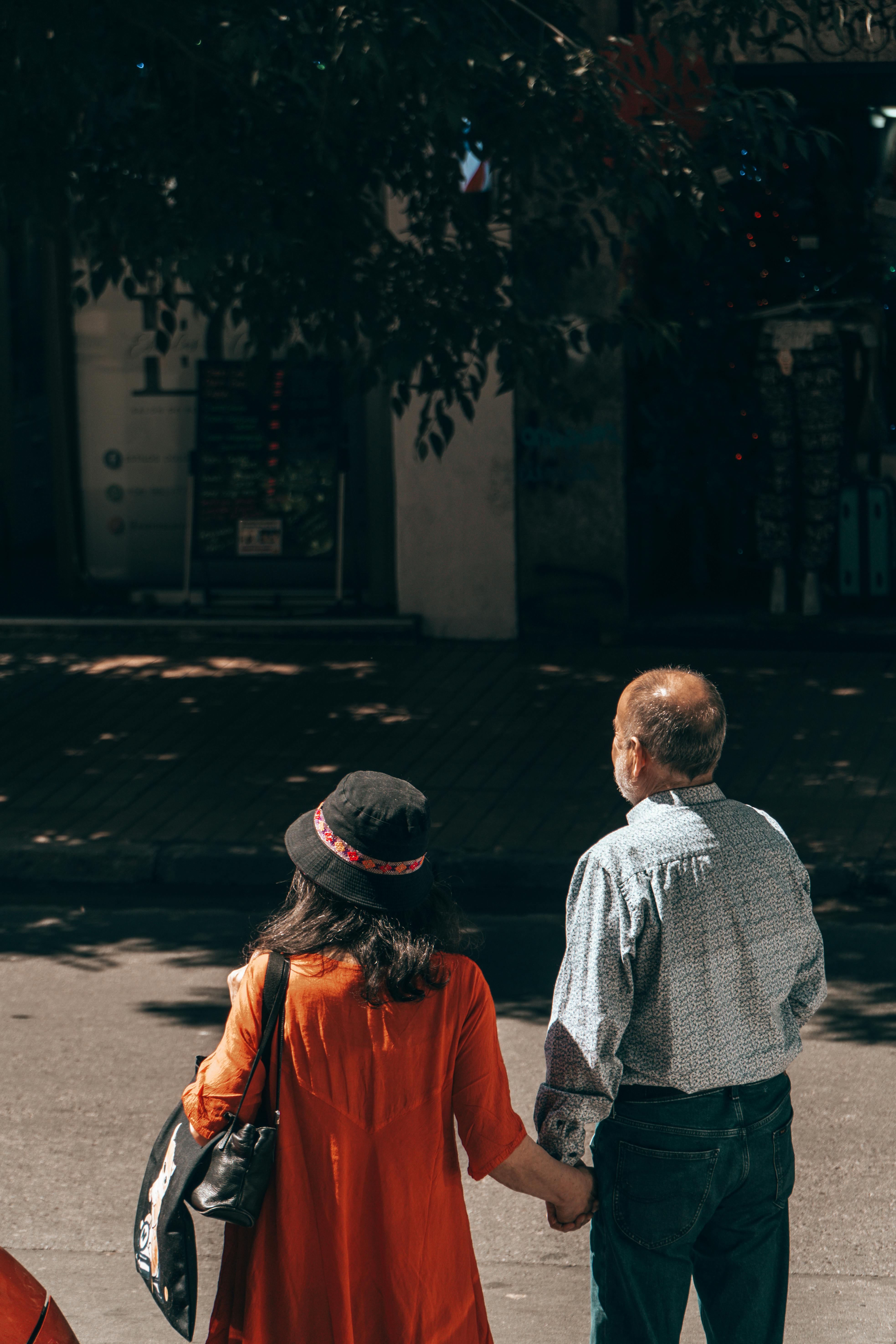 bezplatná Upřímná pouliční fotografie páru kráčejícího ruku v ruce v Santiagu v Chile. Základová fotografie