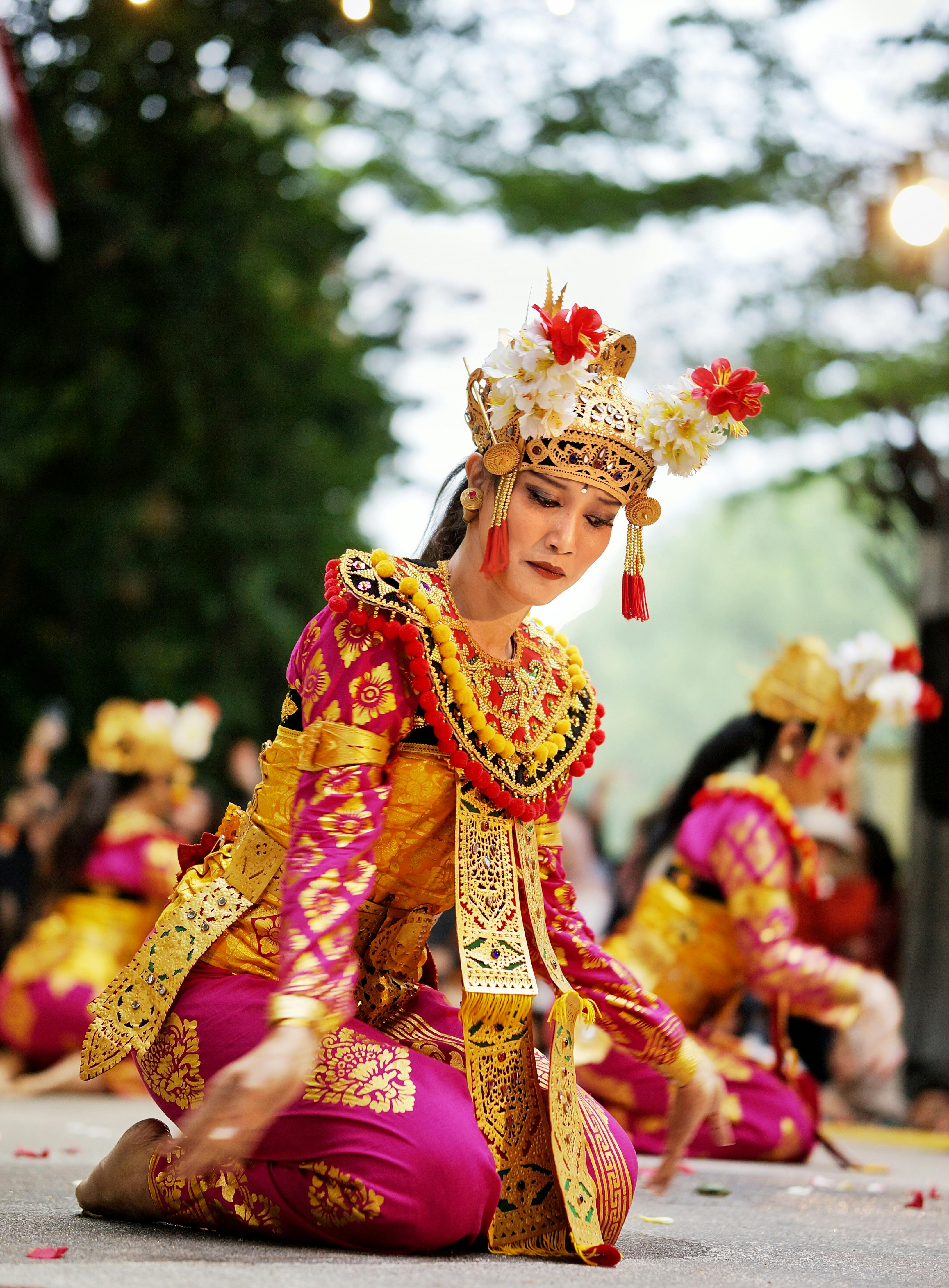 Miễn phí Một vũ công Bali quyến rũ biểu diễn trong trang phục truyền thống rực rỡ cùng với những người khác, tạo nên một cảnh tượng văn hóa ngoài trời. Ảnh lưu trữ