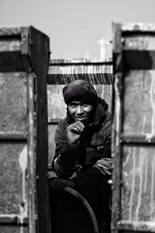 Black and white of ethnic male worker in warm clothes during working day in factory