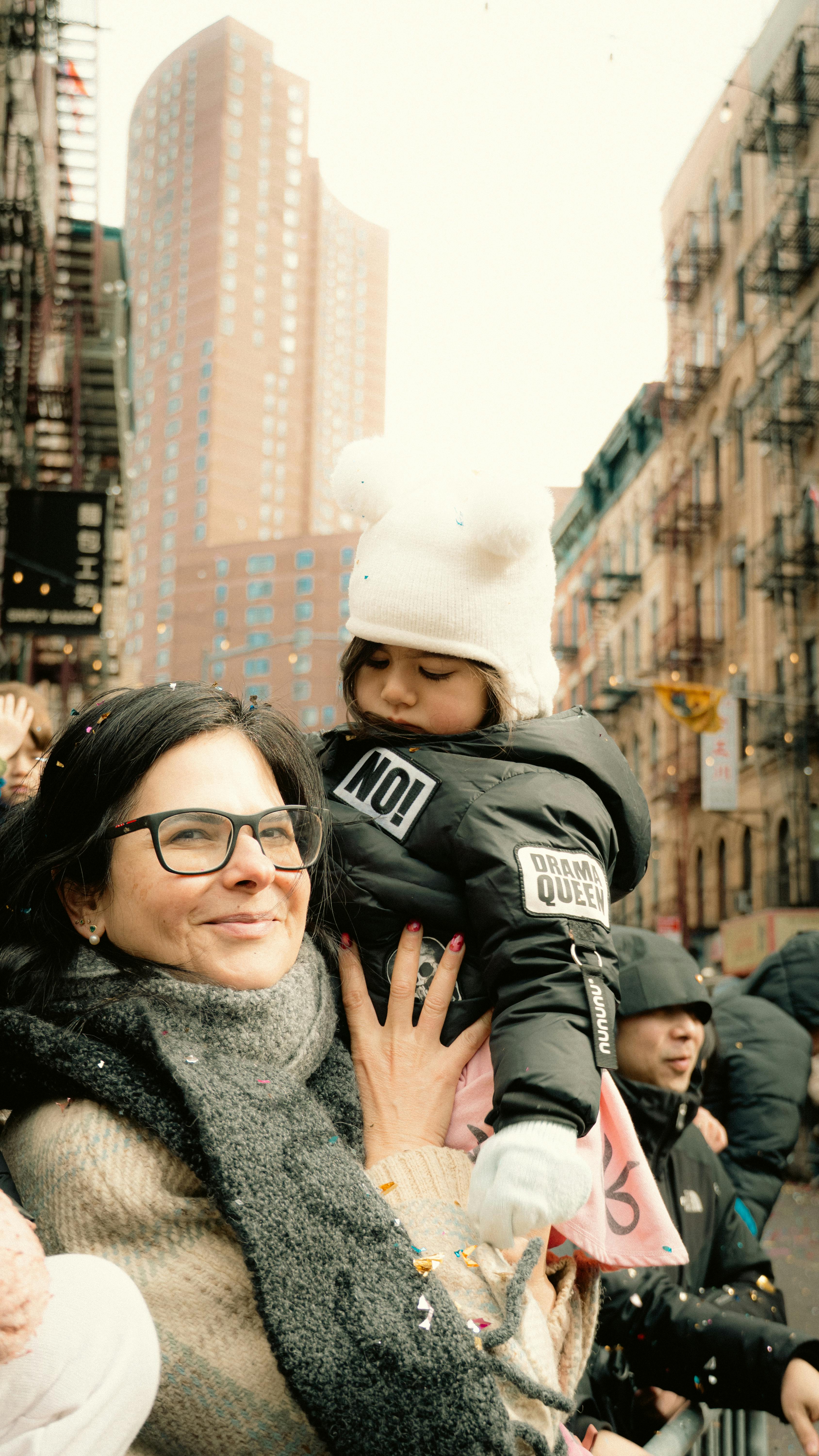 Zadarmo Matka s dieťaťom sa objímajú uprostred živého pouličného sprievodu v New Yorku. Fotka z fotobanky