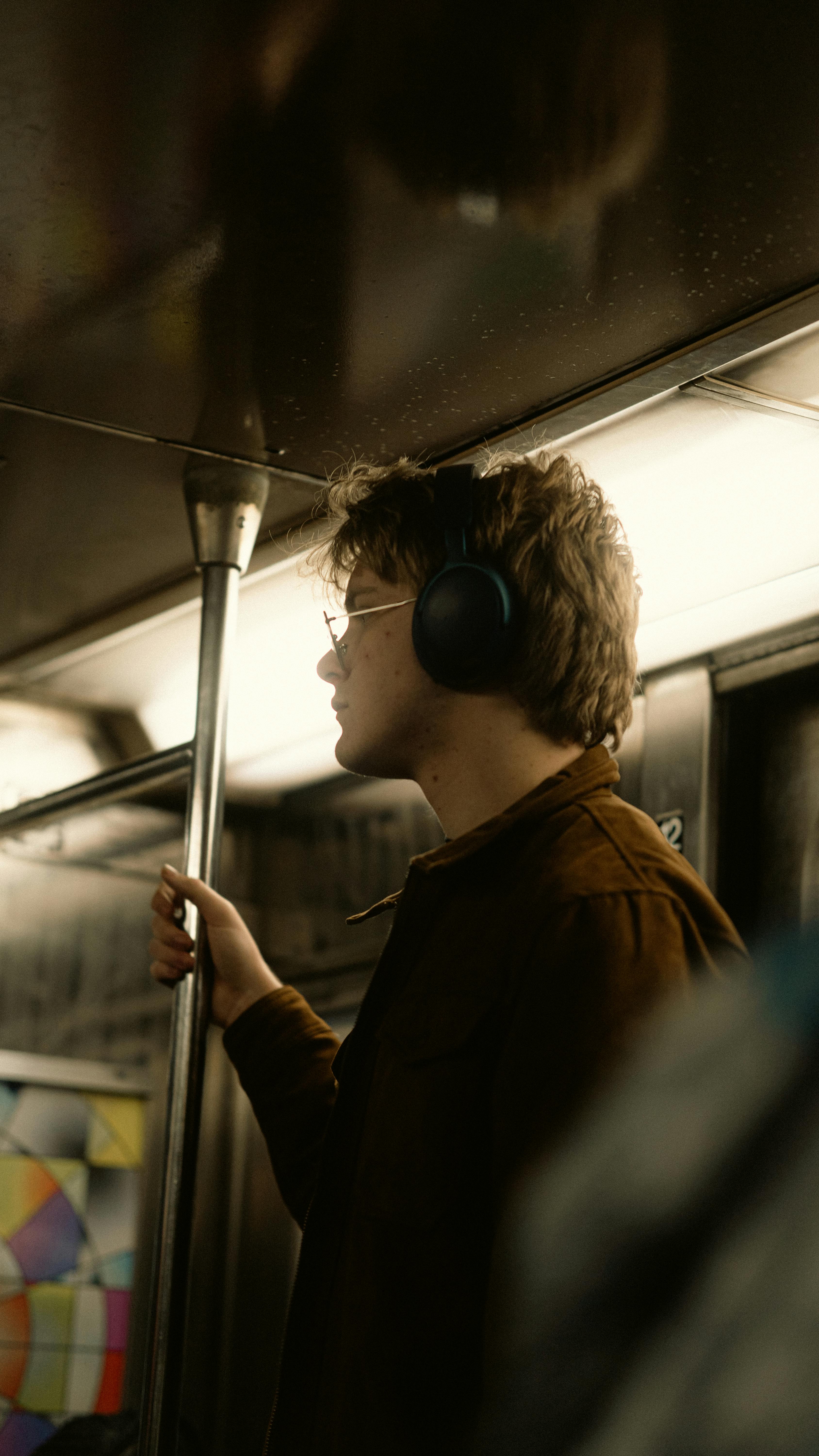 ingyenes Oldalnézetből egy fiatalember fejhallgatóval egy New York-i metrón. Stockfotó