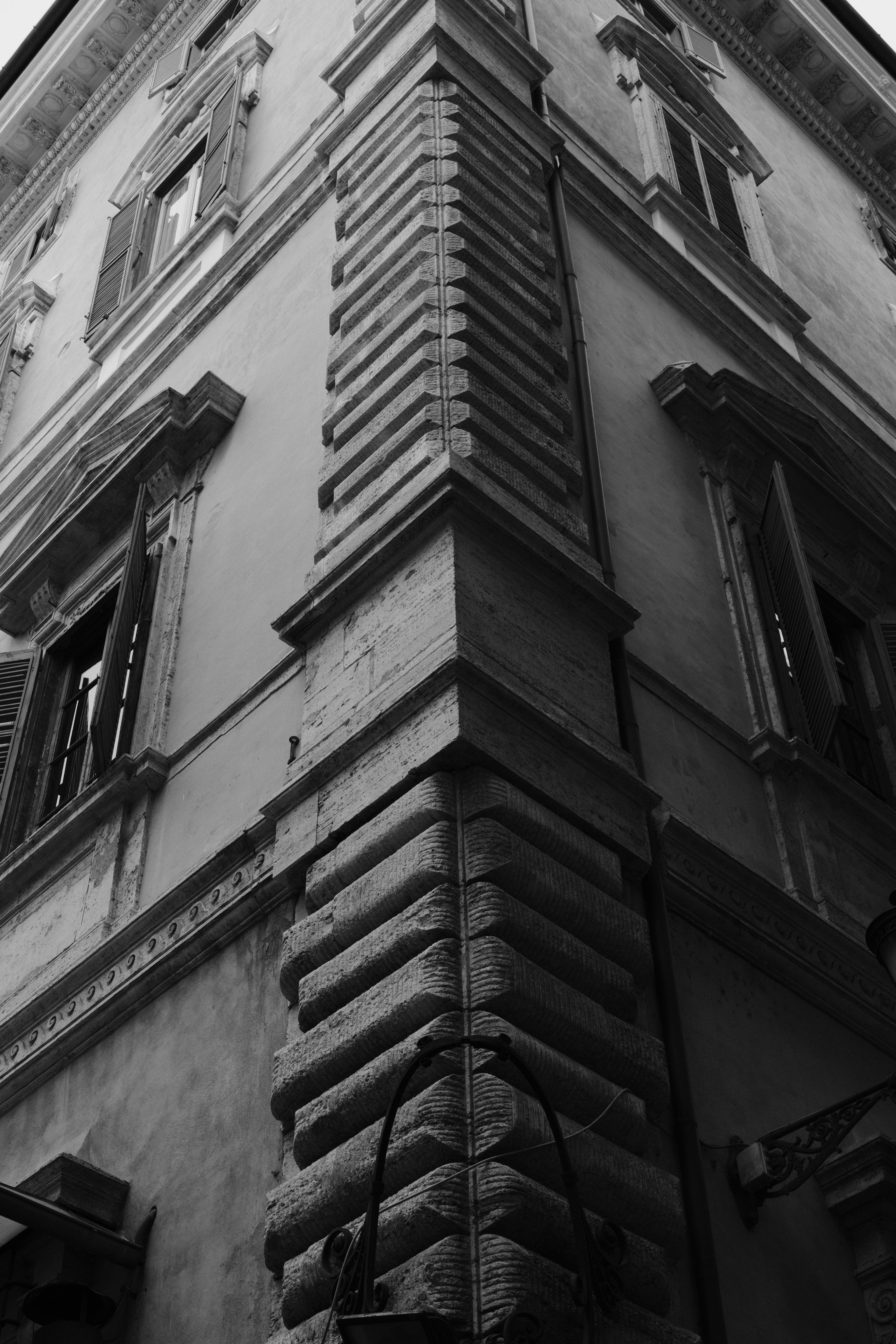 Miễn phí Ảnh đen trắng ghi lại những chi tiết tinh xảo trên mặt tiền của một tòa nhà lịch sử ở góc phố Rome, Ý. Ảnh lưu trữ