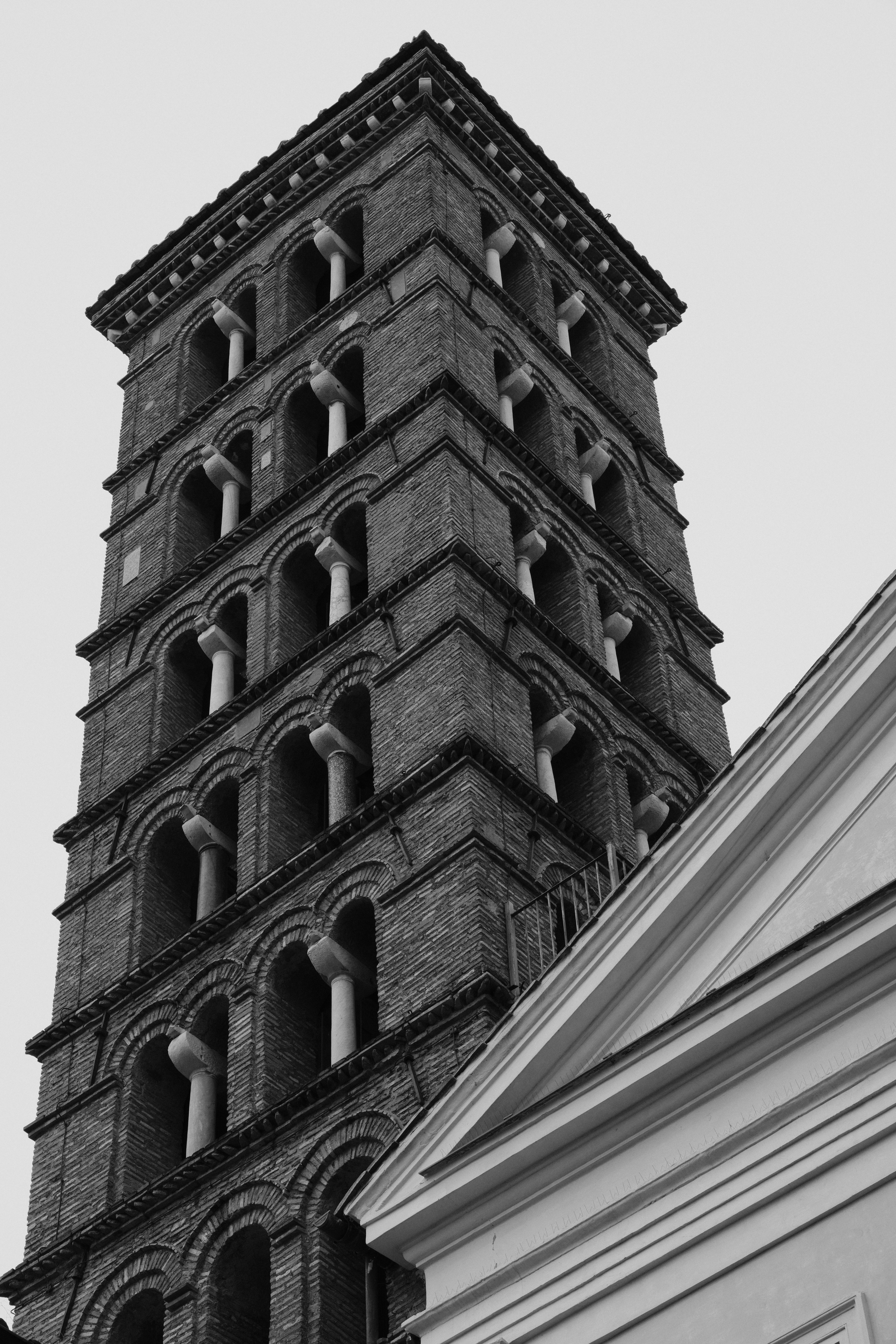 Zadarmo Čiernobiela fotografia historickej tehlovej veže v Ríme, ktorá ukazuje architektonické detaily. Fotka z fotobanky