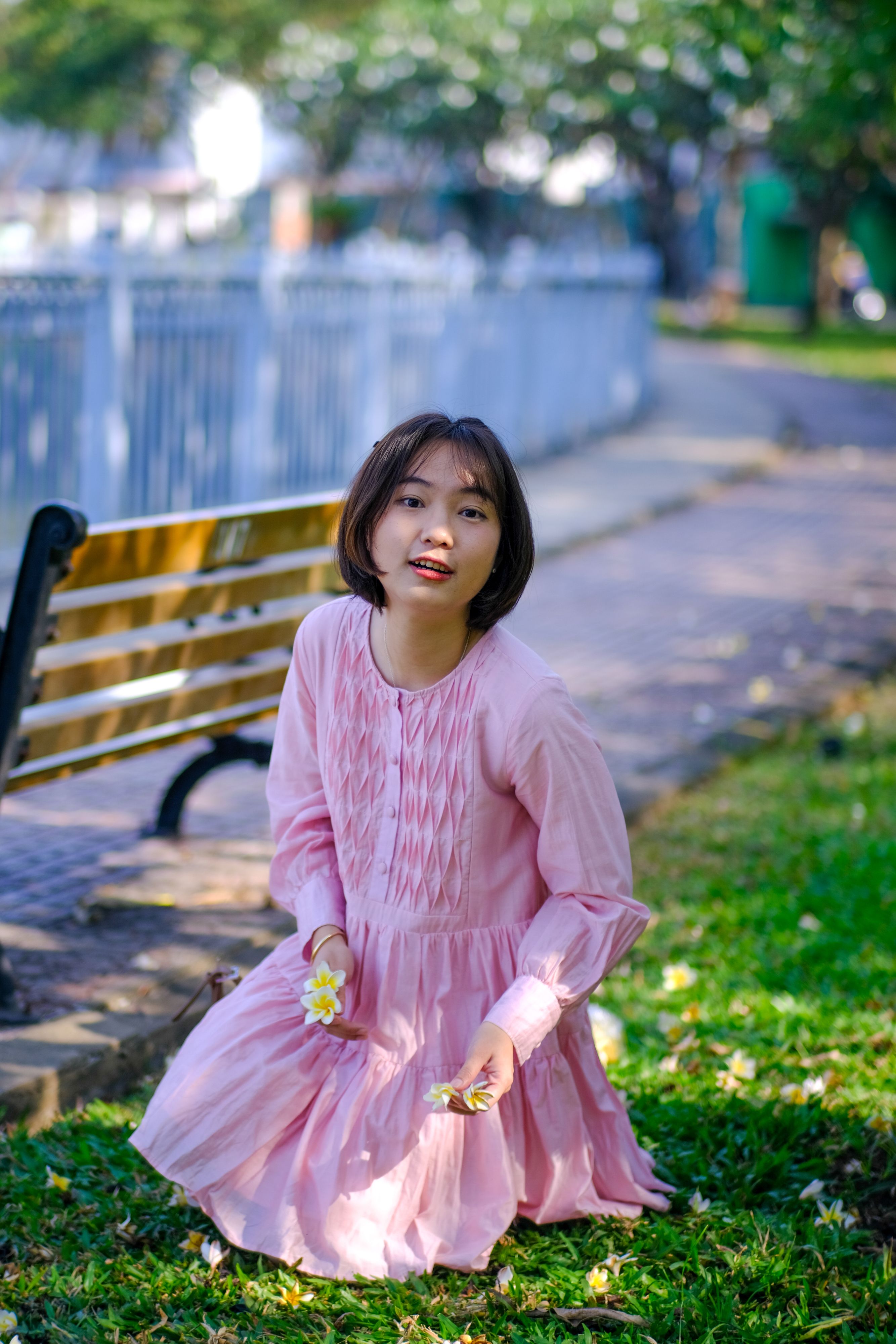 Young Woman in Pink Dress Holding Flowers · Free Stock Photo