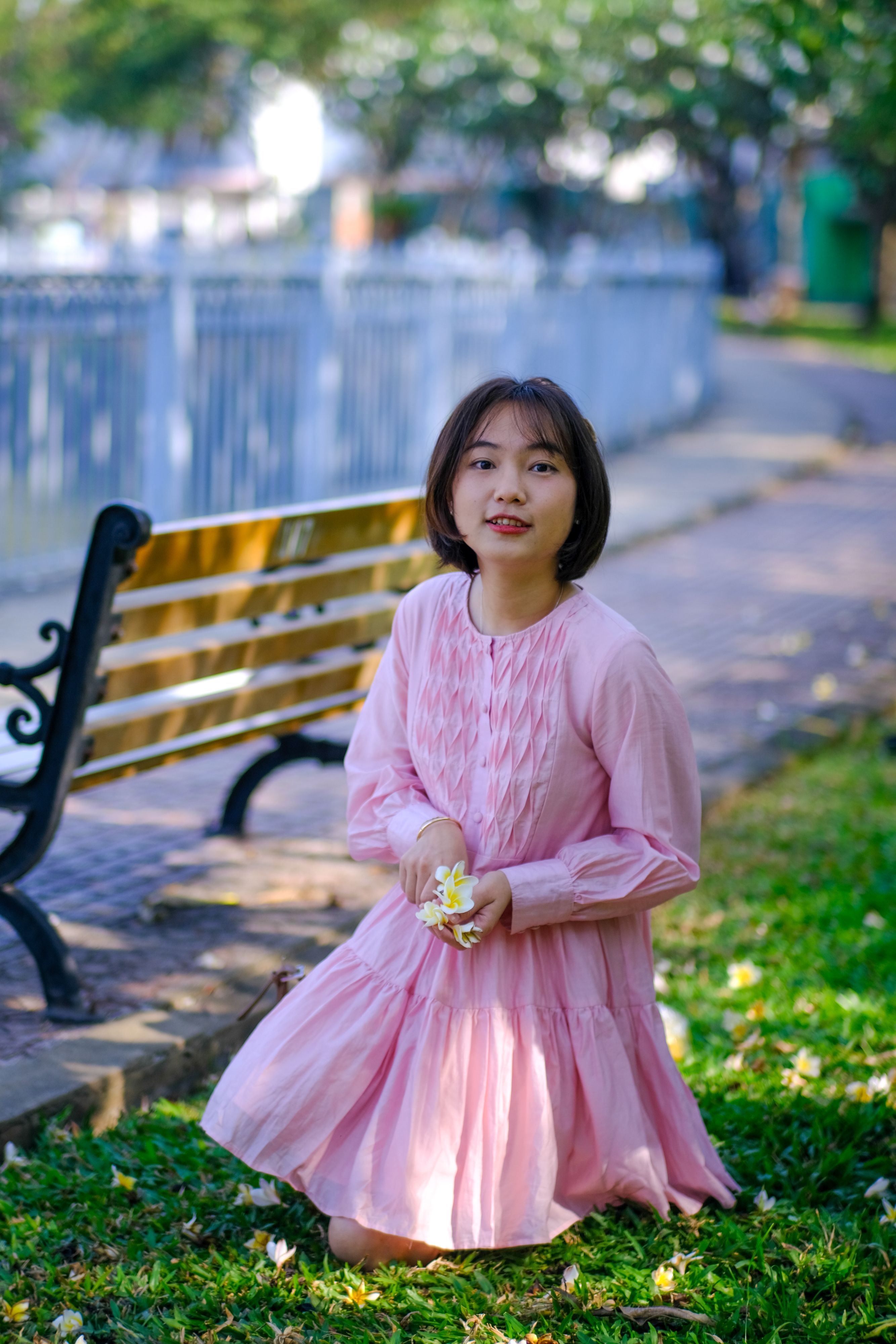 Elegant Woman in Pink Dress Kneeling in Park · Free Stock Photo