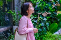 Woman in Pink Dress Enjoying a Garden View