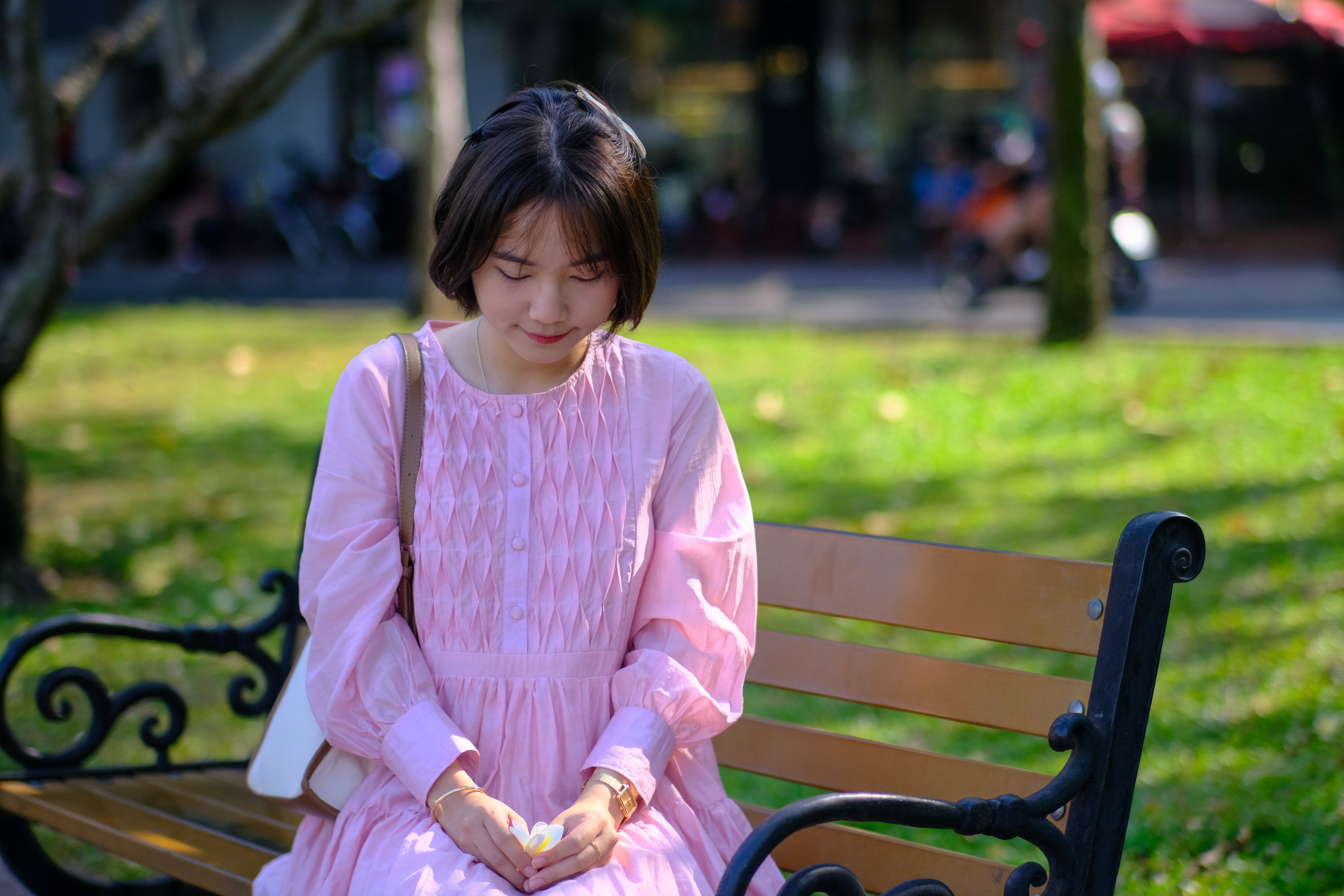 Young Woman in Pink Dress Sitting on Park Bench · Free Stock Photo