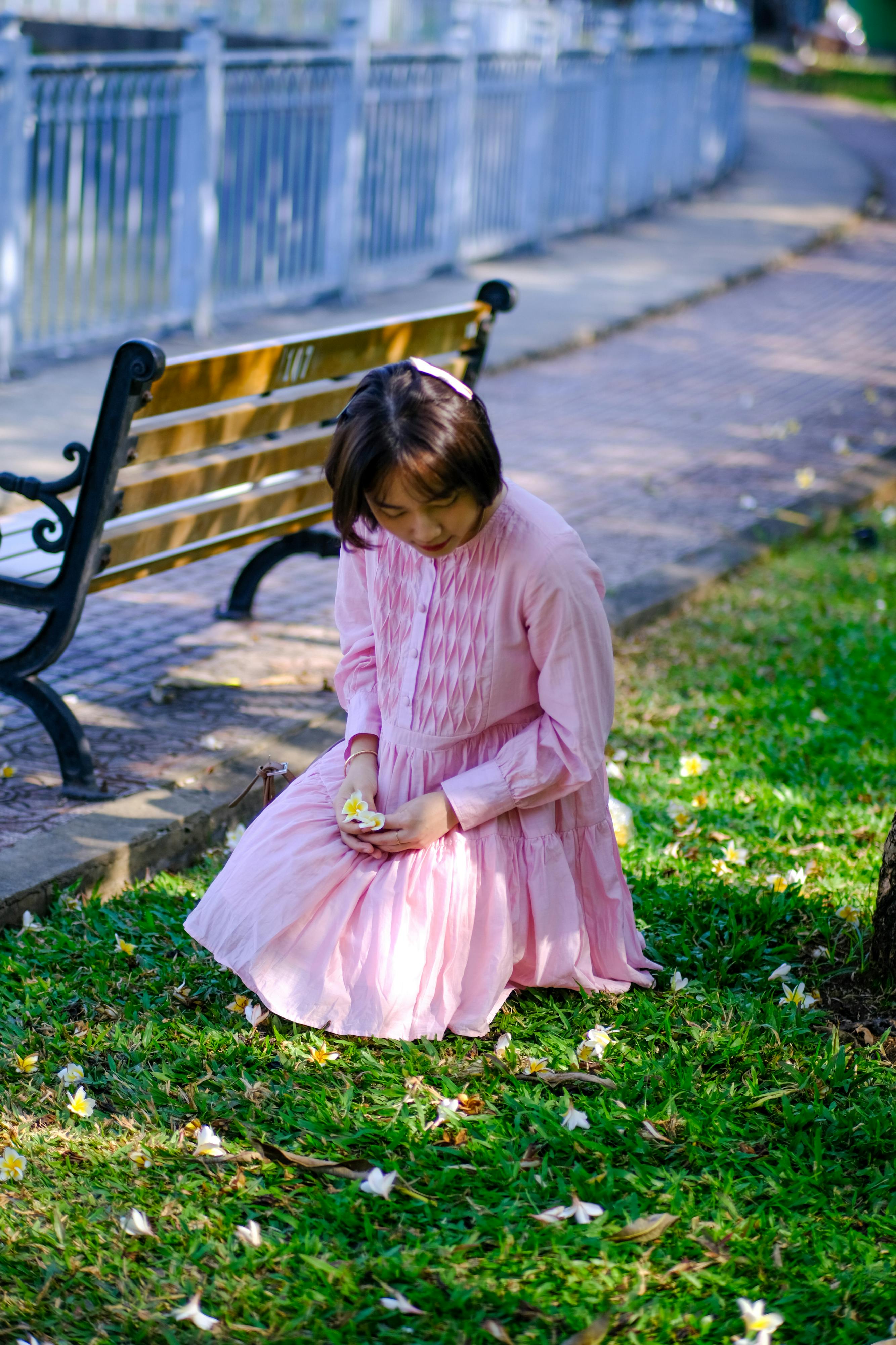 ฟรี ภาพบรรยากาศสงบสุขของหญิงสาวในชุดสีชมพูกำลังเพลิดเพลินกับธรรมชาติในสวนสาธารณะแห่งหนึ่งในเมืองโฮจิมินห์ ประเทศเวียดนาม คลังภาพถ่าย