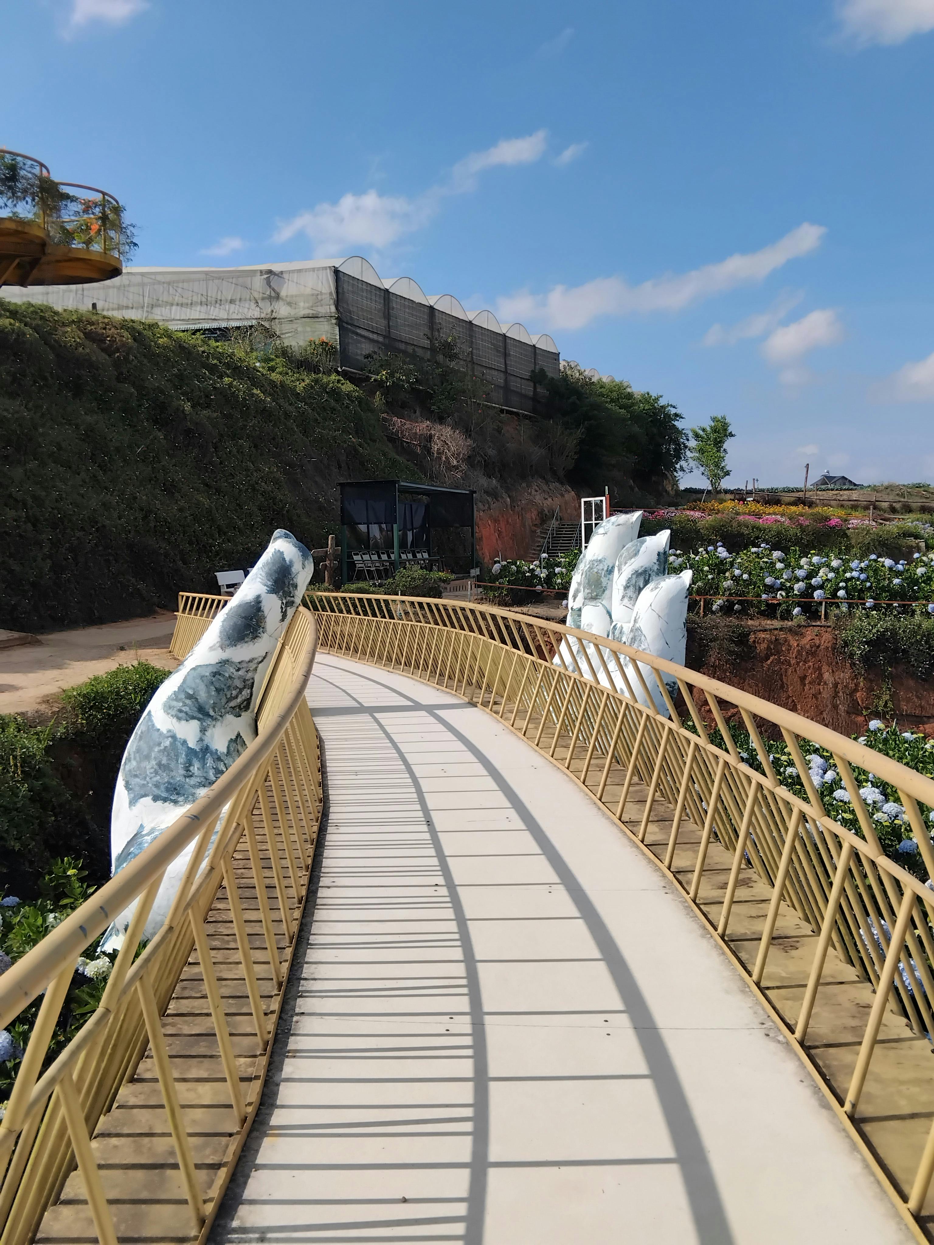 ฟรี ทางเดินกลางแจ้งที่สวยงามประดับประดาด้วยประติมากรรมหินอันเป็นเอกลักษณ์ ในบรรยากาศสวนที่งดงาม คลังภาพถ่าย