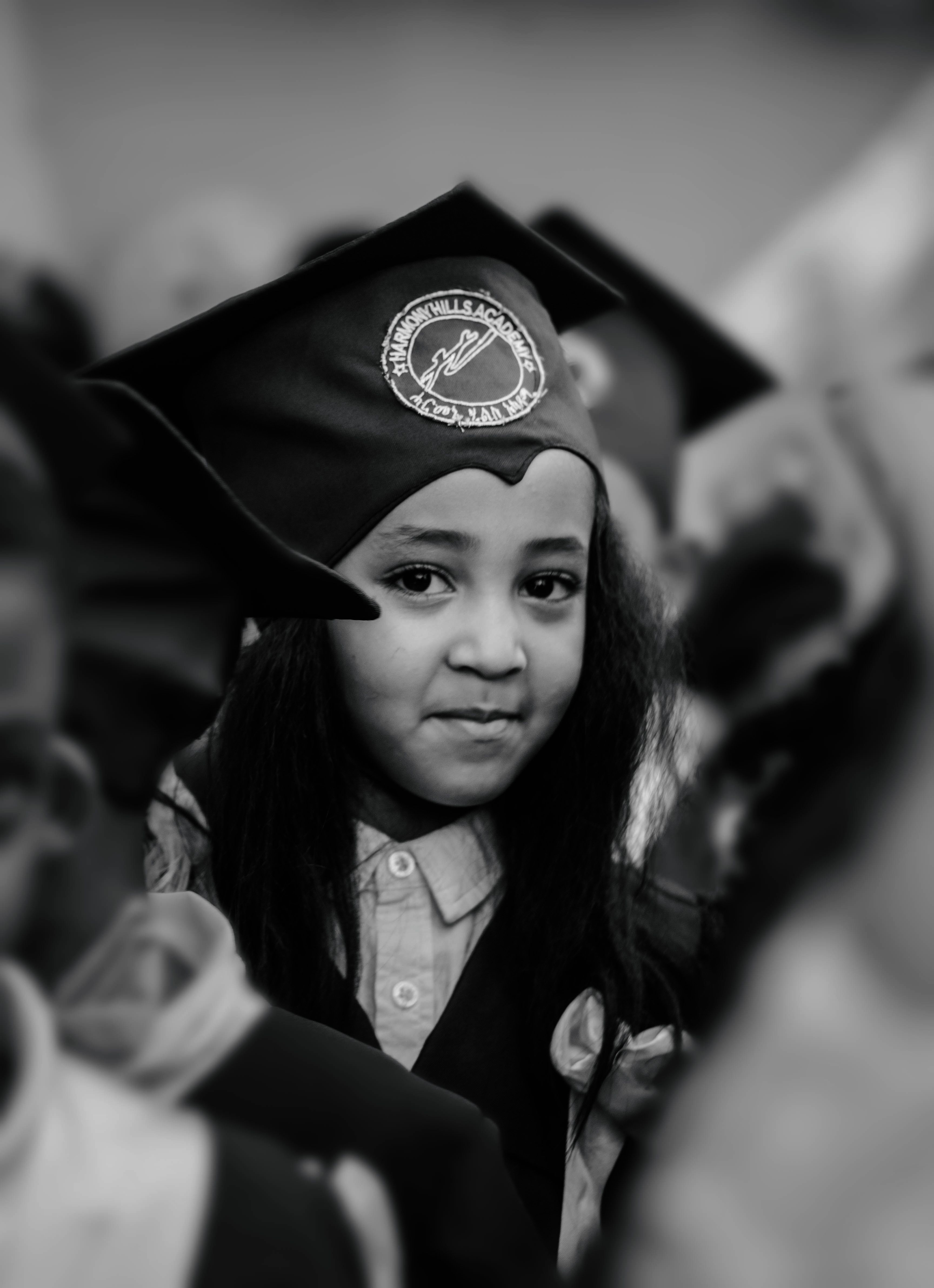 A child in graduation attire smiling proudly, symbolizing success and celebration of educational milestones.