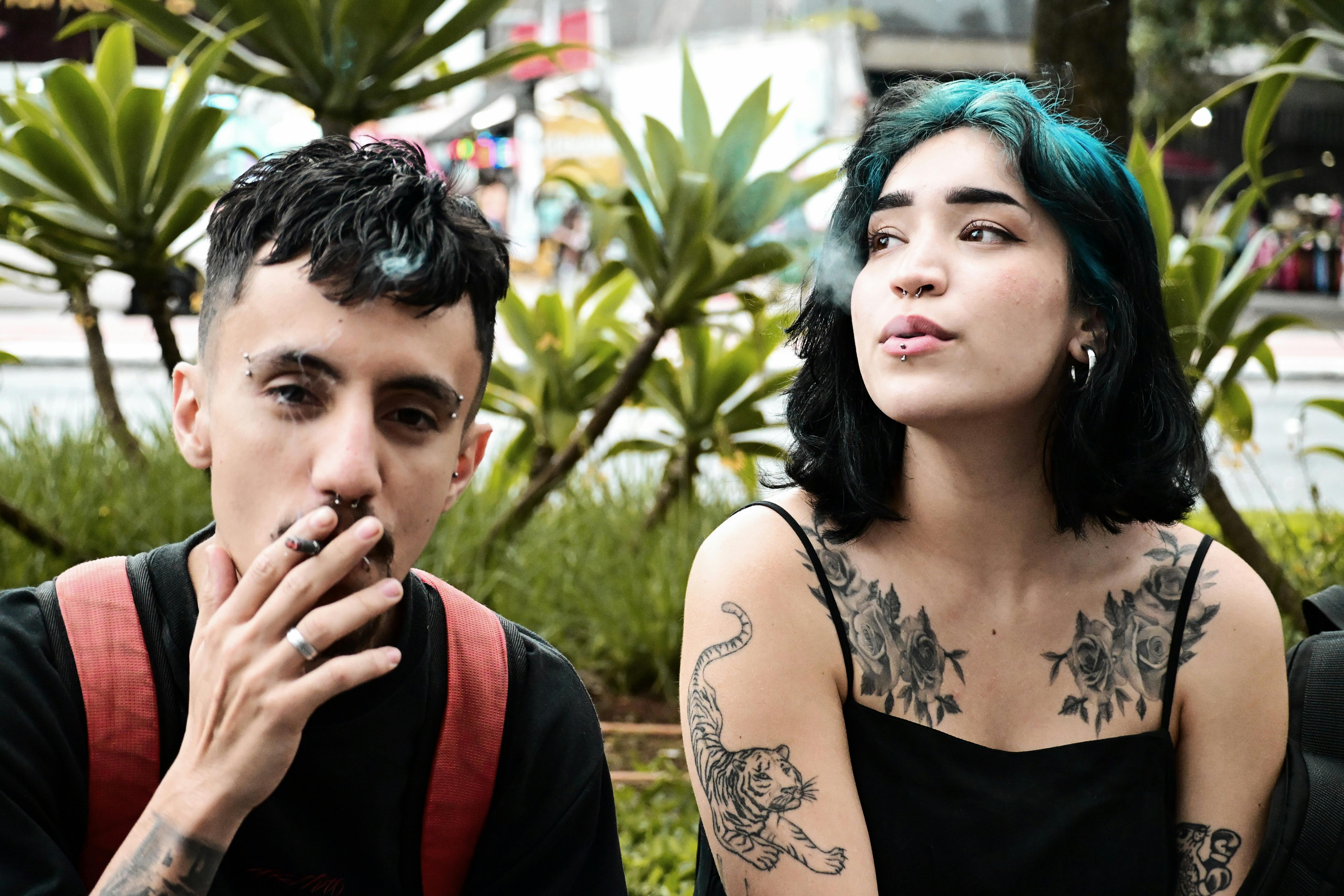 Zadarmo Dvaja štýloví mladí dospelí s tetovaniami a piercingom relaxujú vonku a vyžarujú z nich štýlovú mestskú atmosféru. Fotka z fotobanky