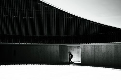 Free A sleek design with a solitary person in a modern architectural setting. High contrast and minimalist style. Stock Photo