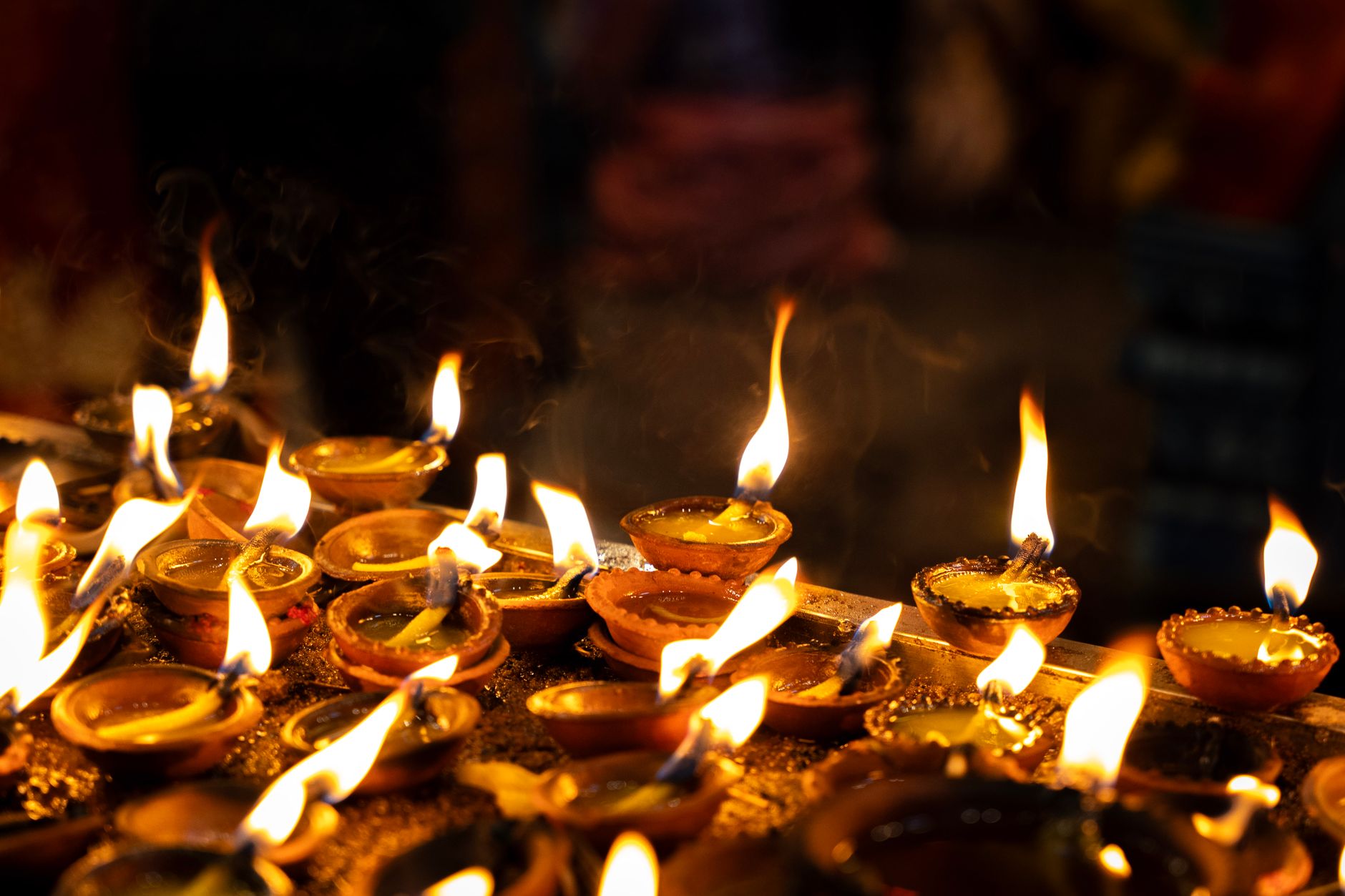 Traditional oil lamps flicker during a vibrant Thiruvizha festival in Matale, Sri Lanka, showcasing cultural richness.