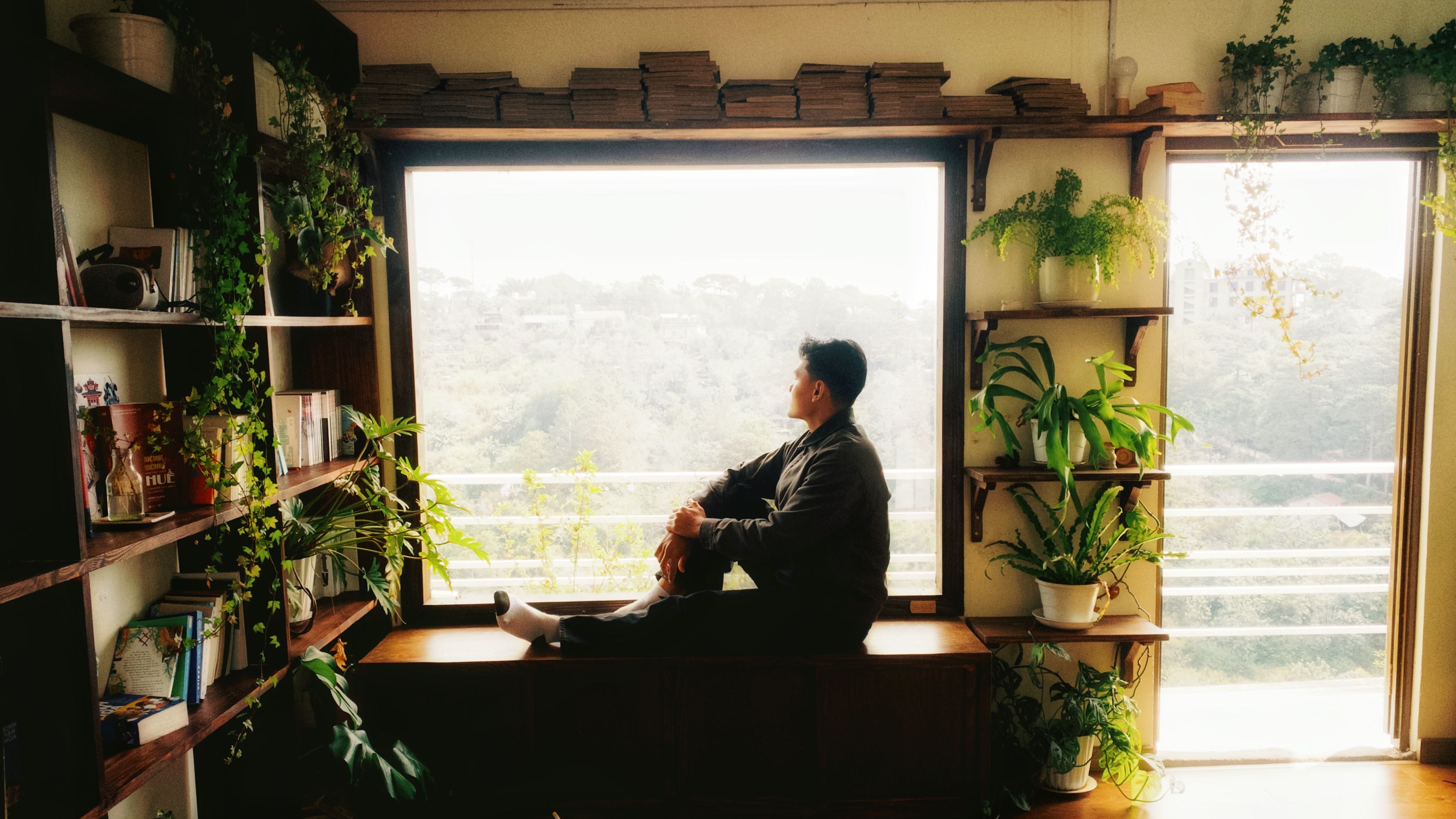 実家の本棚の前で漫画を確認している様子