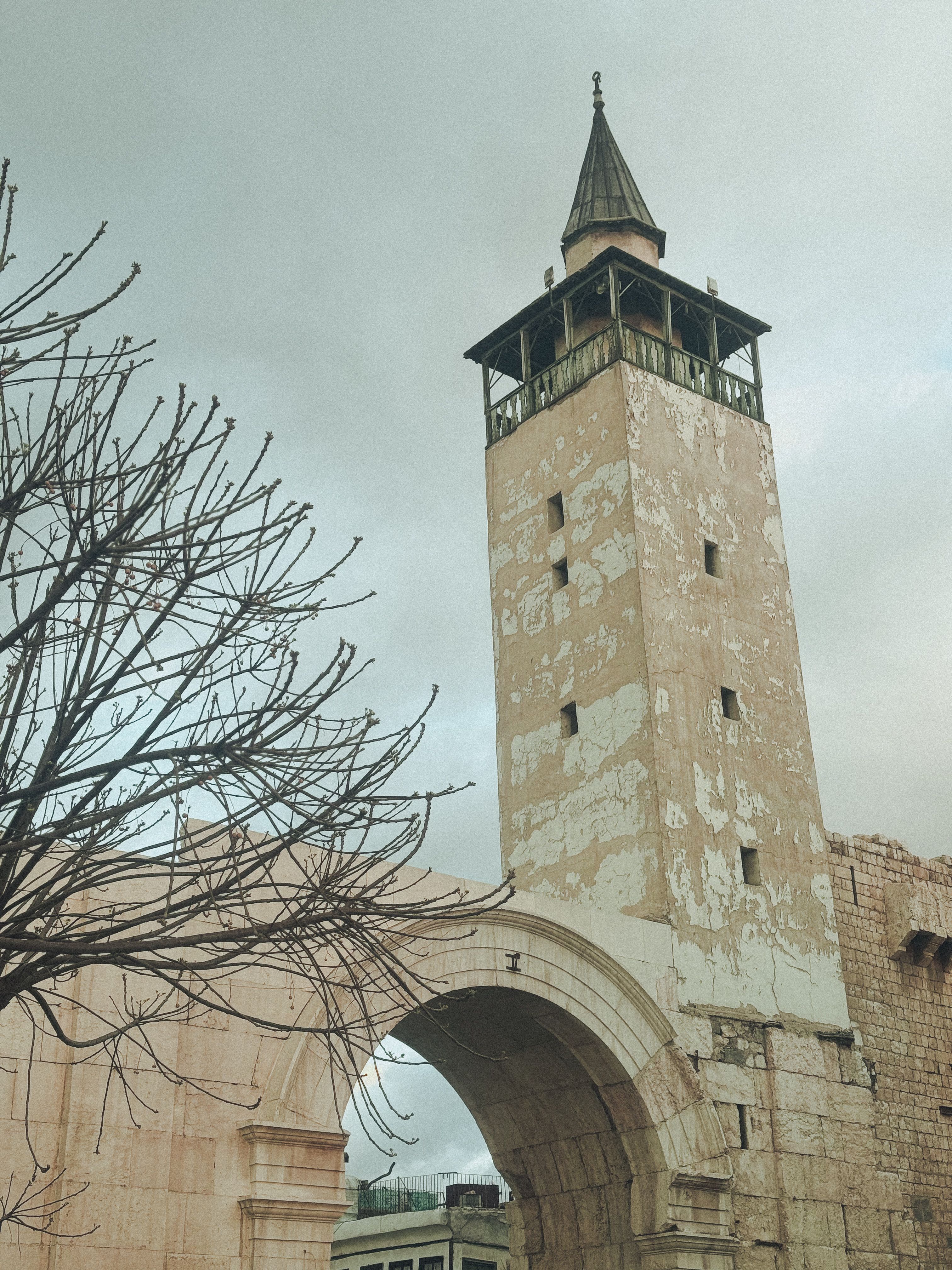 Gratis Historisk minaret og buegang i Damaskus, der indfanger gammel arkitektur under en overskyet himmel. Lagerfoto