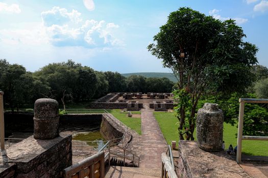 Explore the ancient ruins of Sanchi Stupa amidst lush greenery and blue skies in India.