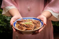 Woman Holding Bowl of Asian Mushroom Dish