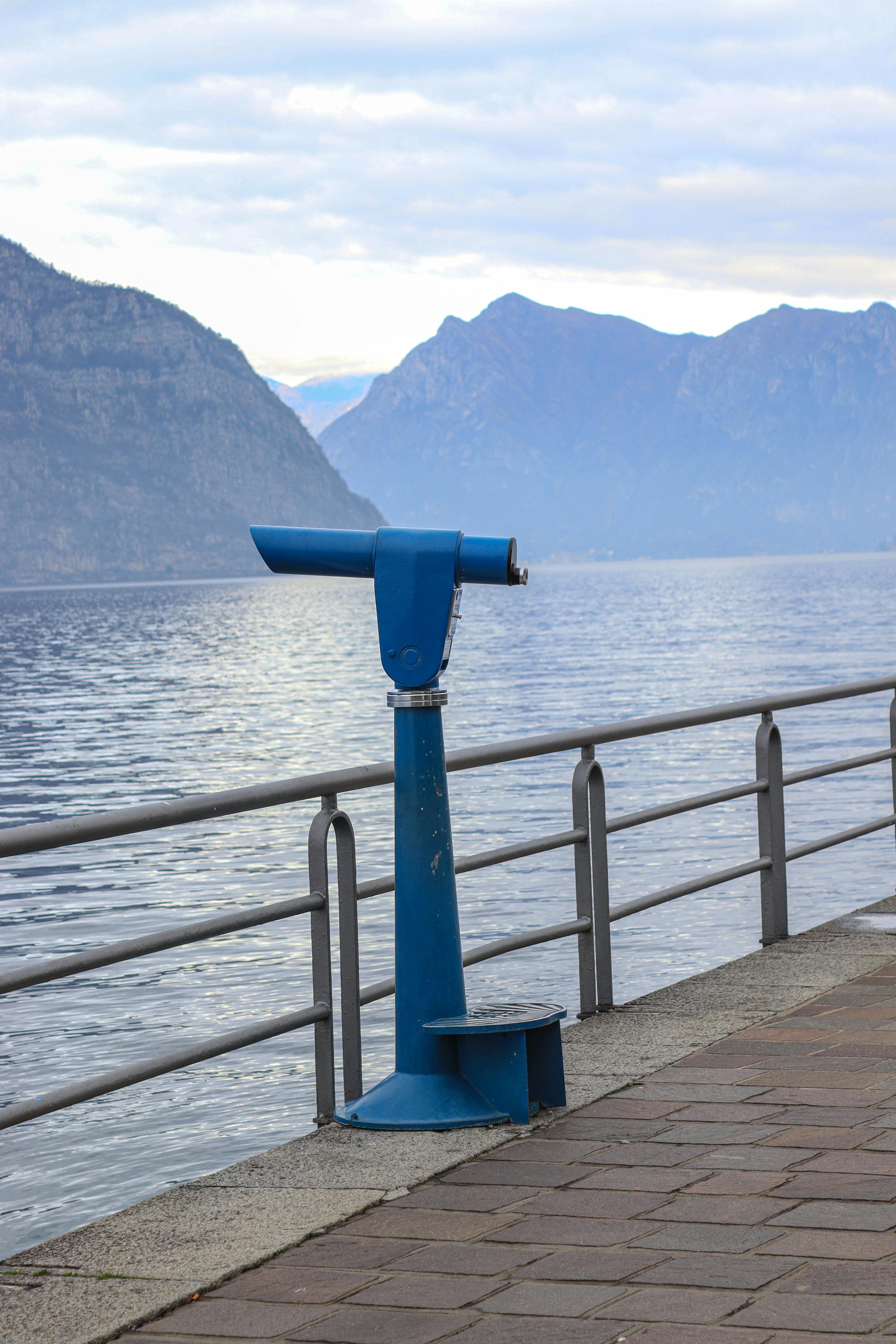 Miễn phí Một chiếc kính thiên văn màu xanh lam được đặt bên cạnh lối đi dạo ven hồ, từ đó có thể nhìn thấy khung cảnh núi non hùng vĩ. Ảnh lưu trữ