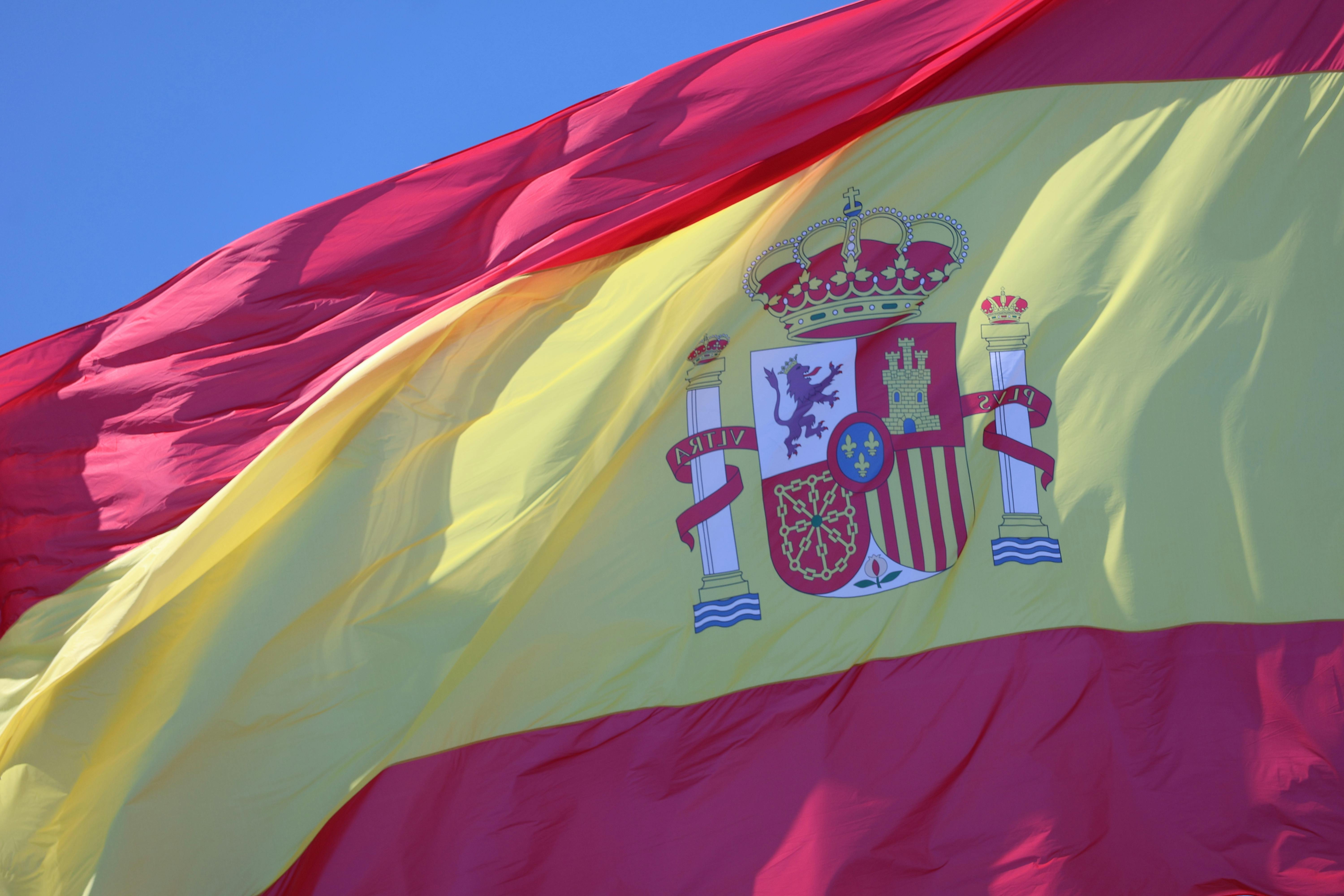 Sunny day view of the Spanish flag waving prominently in Cádiz, Andalucía, Spain.