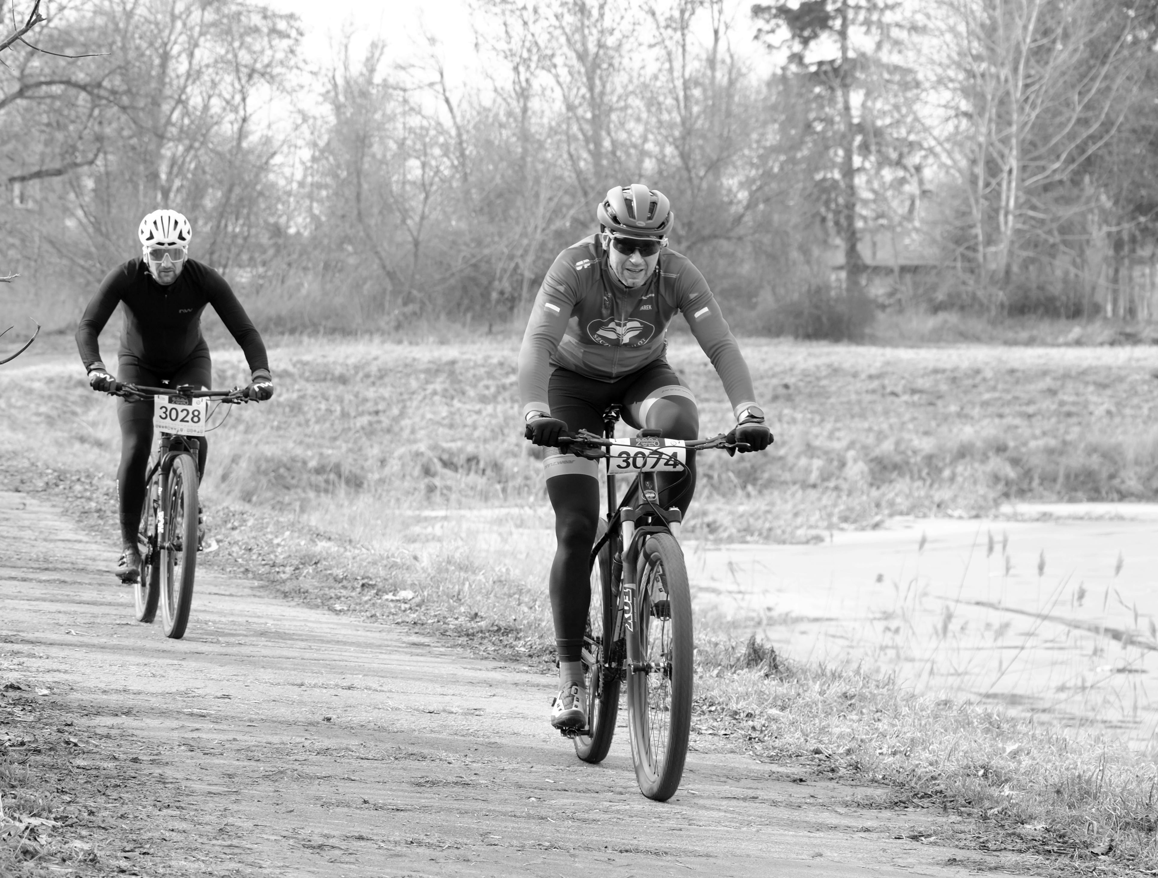 gratis Twee wielrenners nemen deel aan een competitieve race op een landelijk pad, vastgelegd in zwart-wit. Stockfoto