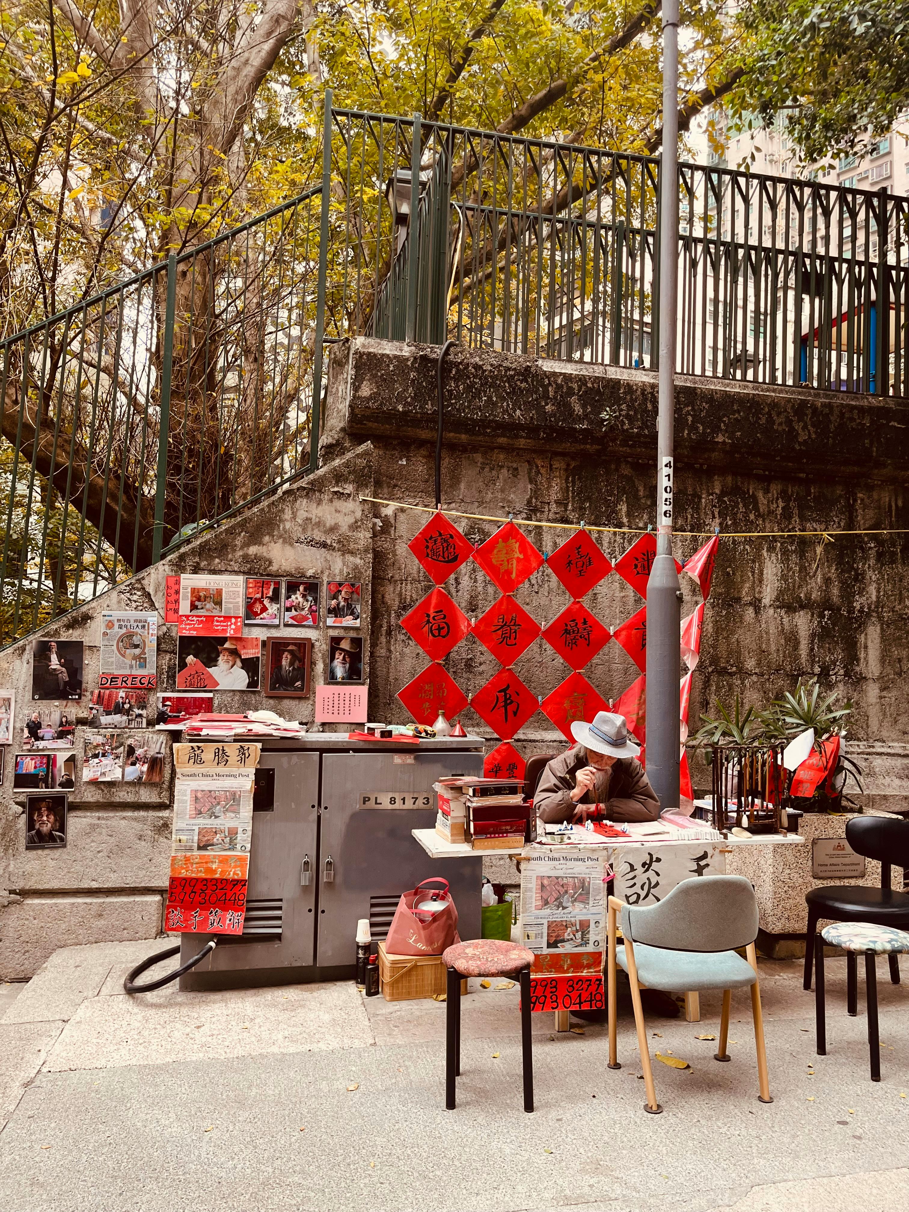 免费 在香港一条古色古香的街道上，一位算命先生的户外摊位以传统中式装饰为特色。 素材图片