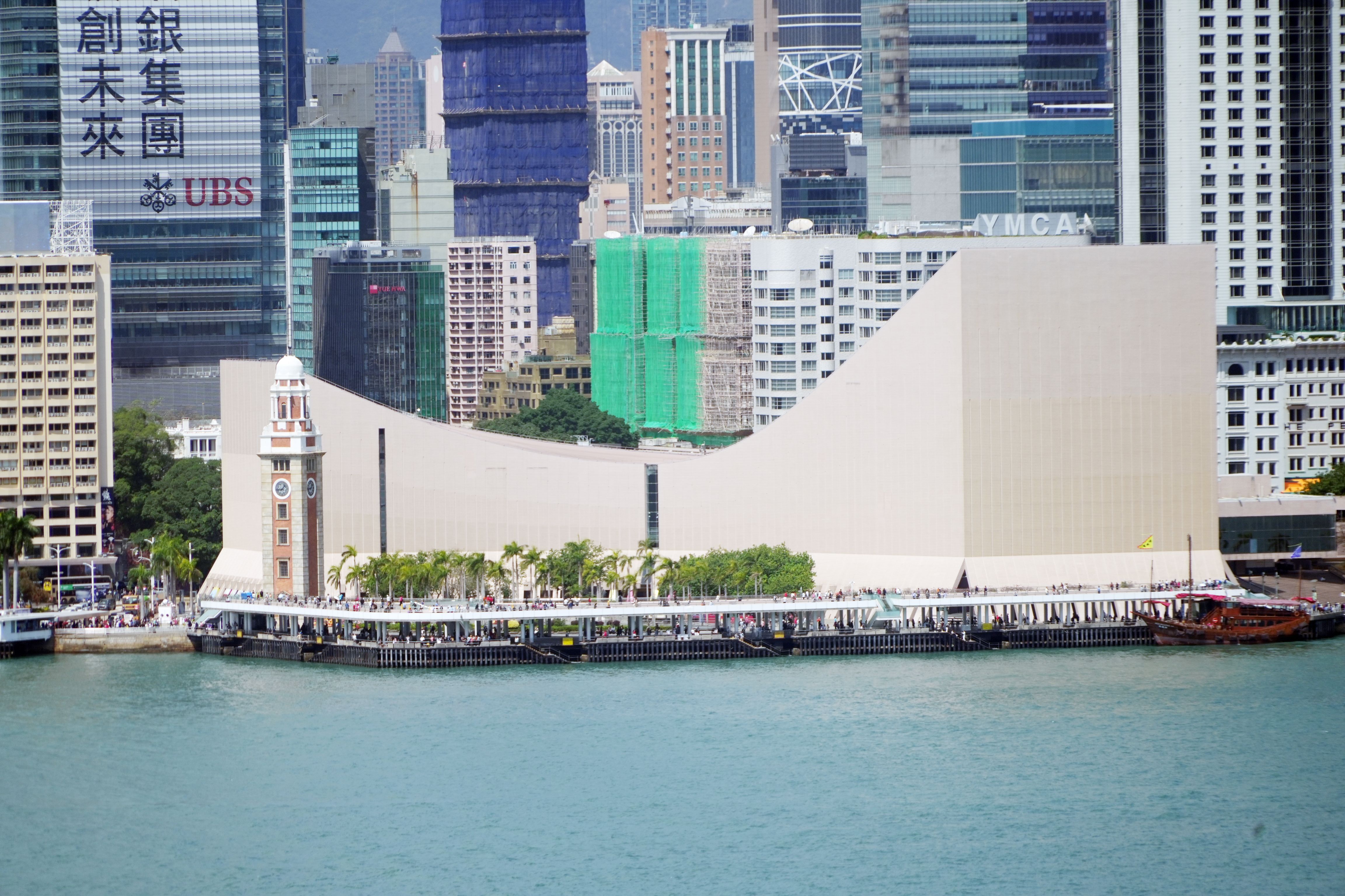 Scenic view of Victoria Harbour and Tsim Sha Tsui Promenade in Hong Kong's bustling urban skyline.