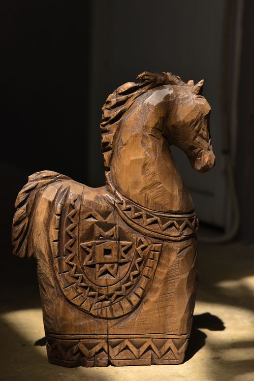Free Detailed wooden horse carving with ethnic patterns in natural light. Stock Photo