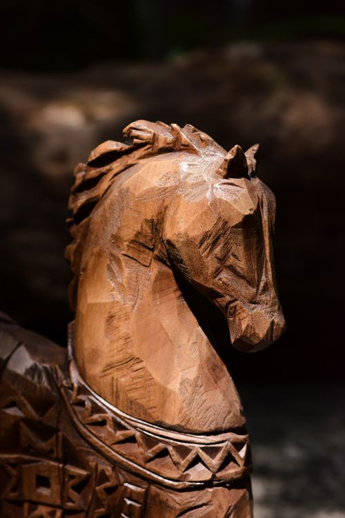 Free Intricate wooden horse sculpture captured in natural sunlight showcasing craftsmanship. Stock Photo