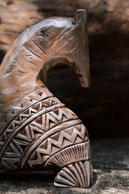 Free Close-up of a detailed wooden horse statue featuring traditional patterns, illuminated by sunlight. Stock Photo