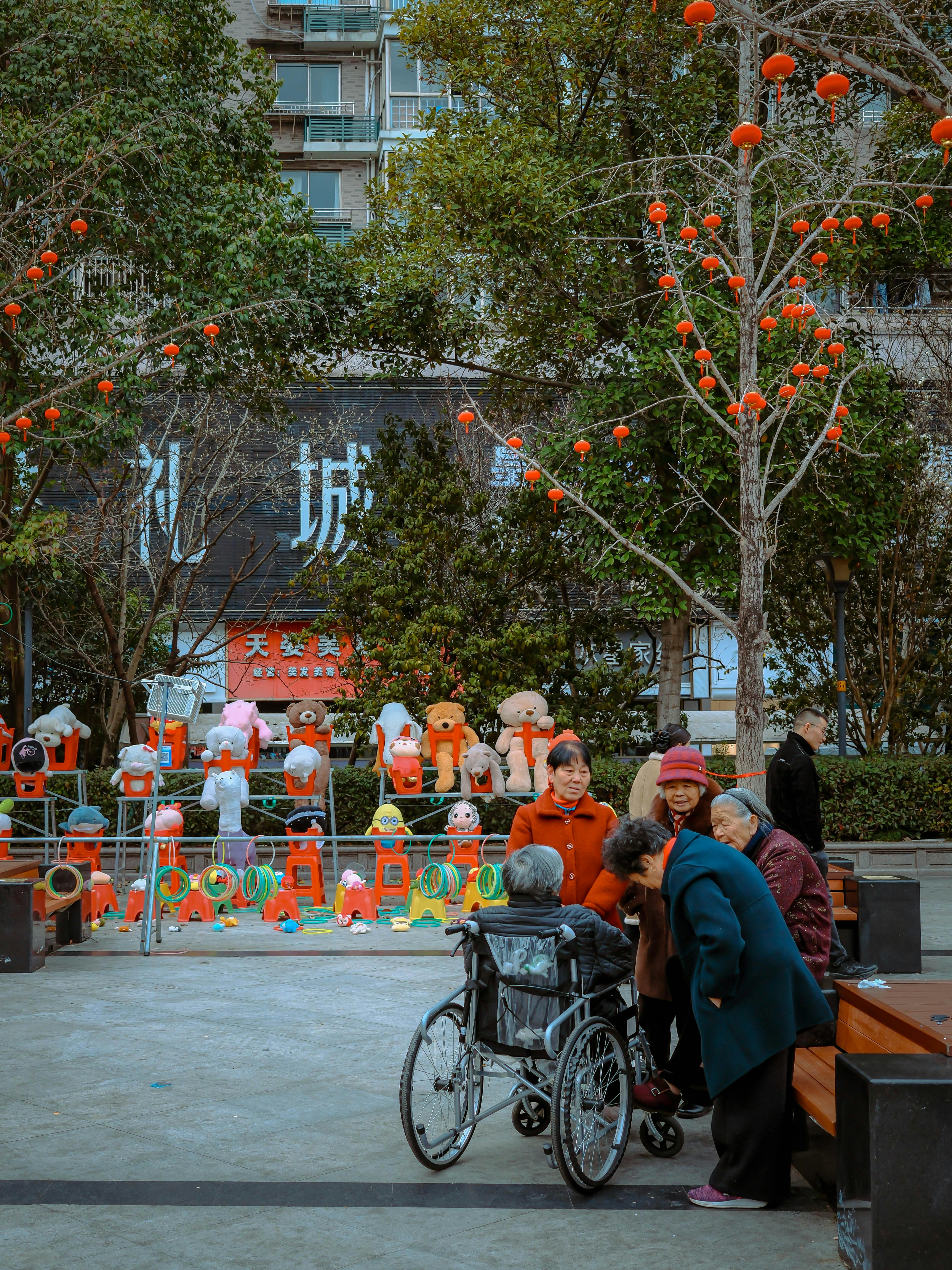 무료 어르신들이 활기찬 도심 공원에 모여 즐거운 시간을 보내고 담소를 나눕니다. 공원은 밝고 경쾌한 분위기로 꾸며져 있습니다. 스톡 사진