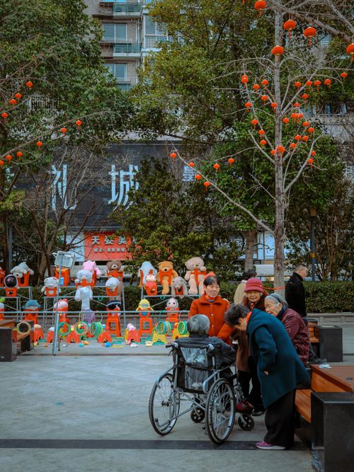 Free Senior adults gather and socialize in a vibrant urban park setting with cheerful decorations. Stock Photo