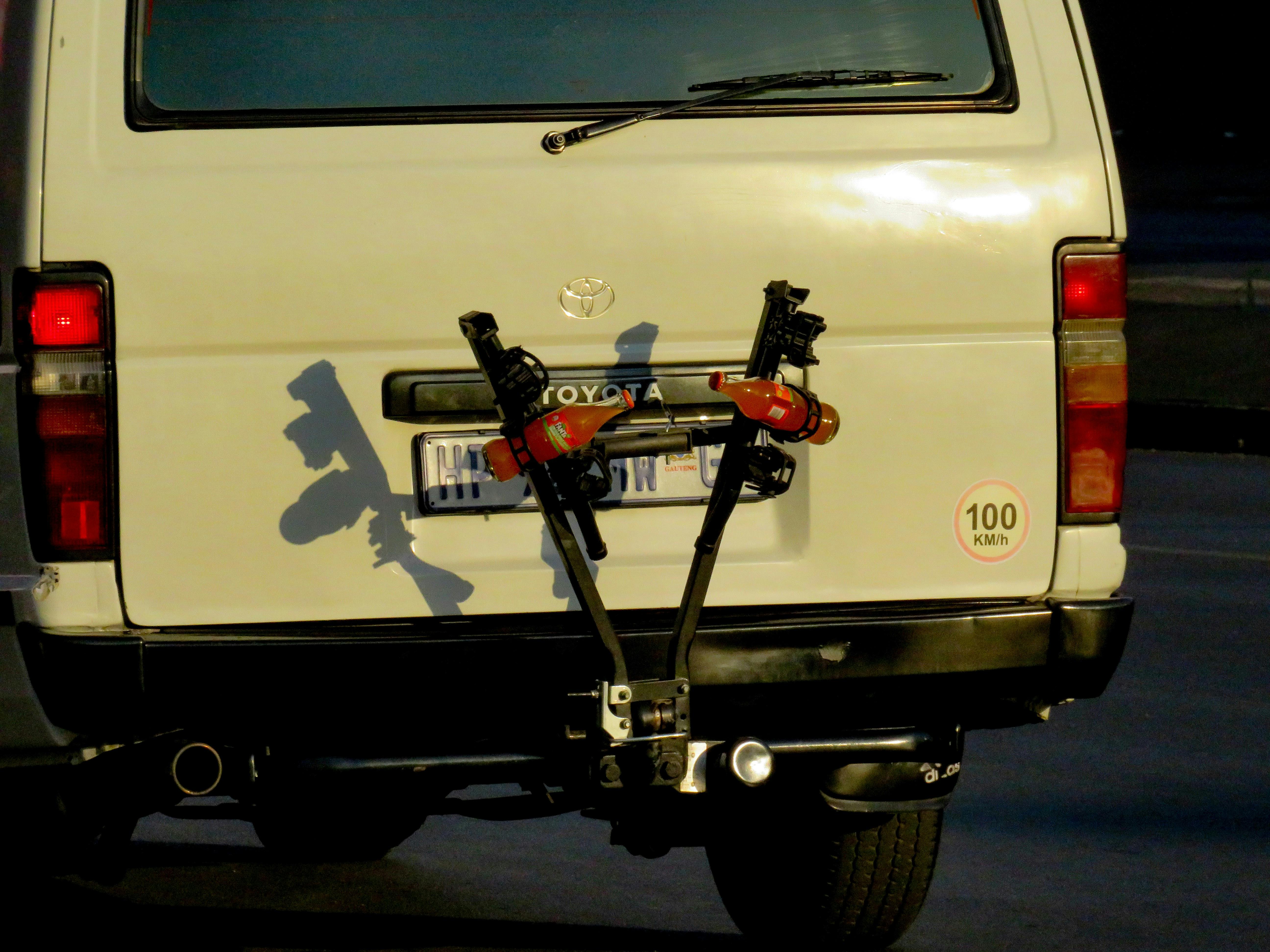 Безкоштовне Задній вид білого фургона з велосипедною стійкою, що відкидає тінь у вечірньому світлі. стокове фото