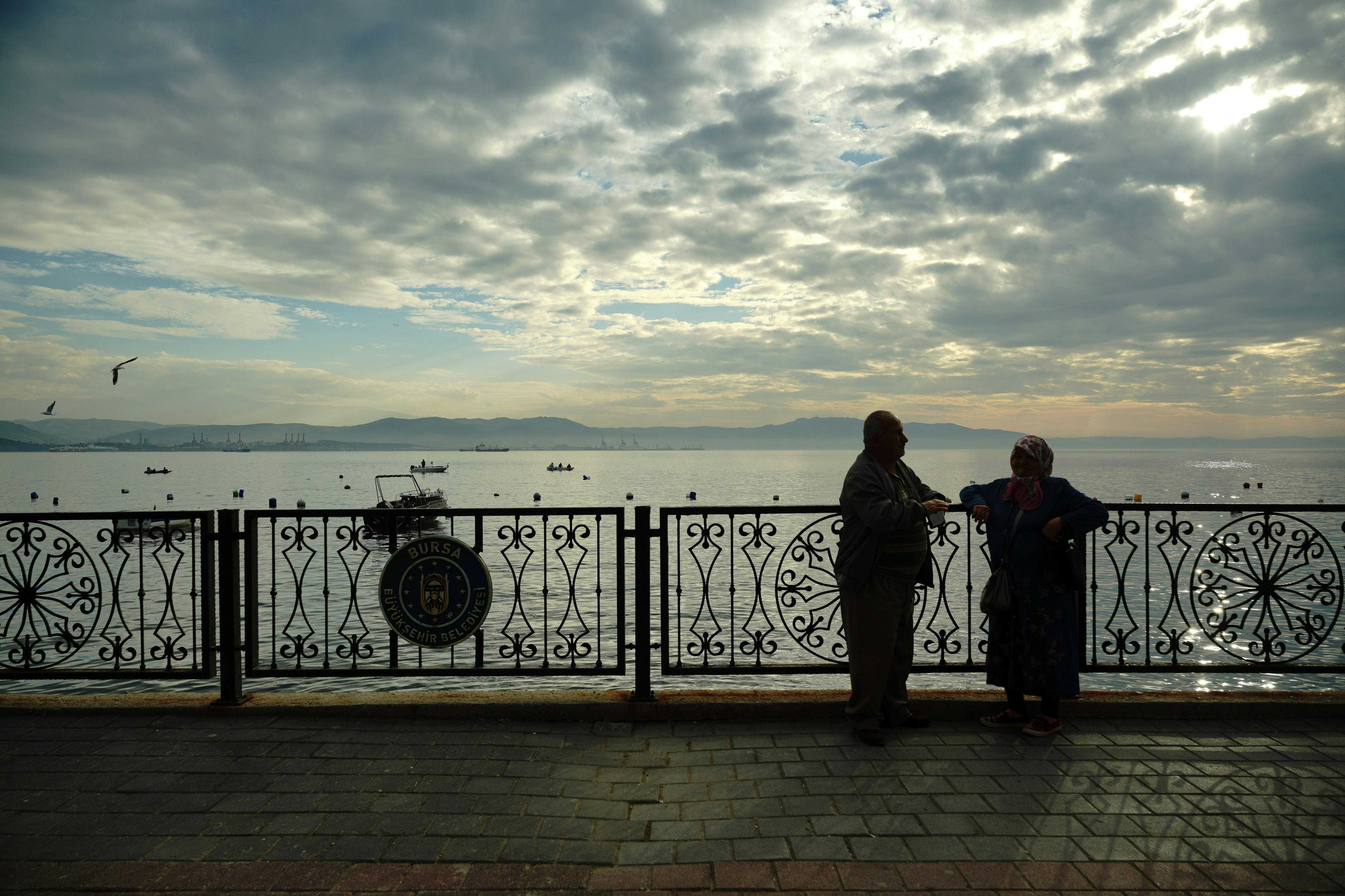 Zadarmo Silueta dvoch ľudí rozprávajúcich sa pri jazere pri východe slnka s krásnou oblohou. Fotka z fotobanky