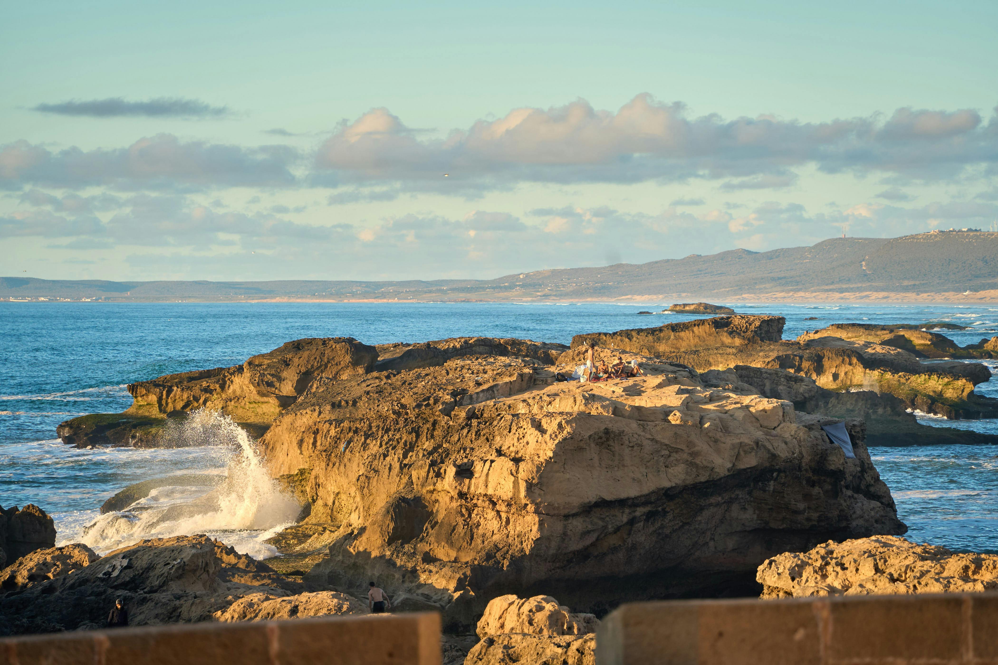 Bezpłatne Przepiękny widok na skaliste wybrzeże w Essaouirze, w Maroku, o zachodzie słońca i fale rozbijające się o skały. Zdjęcie z galerii