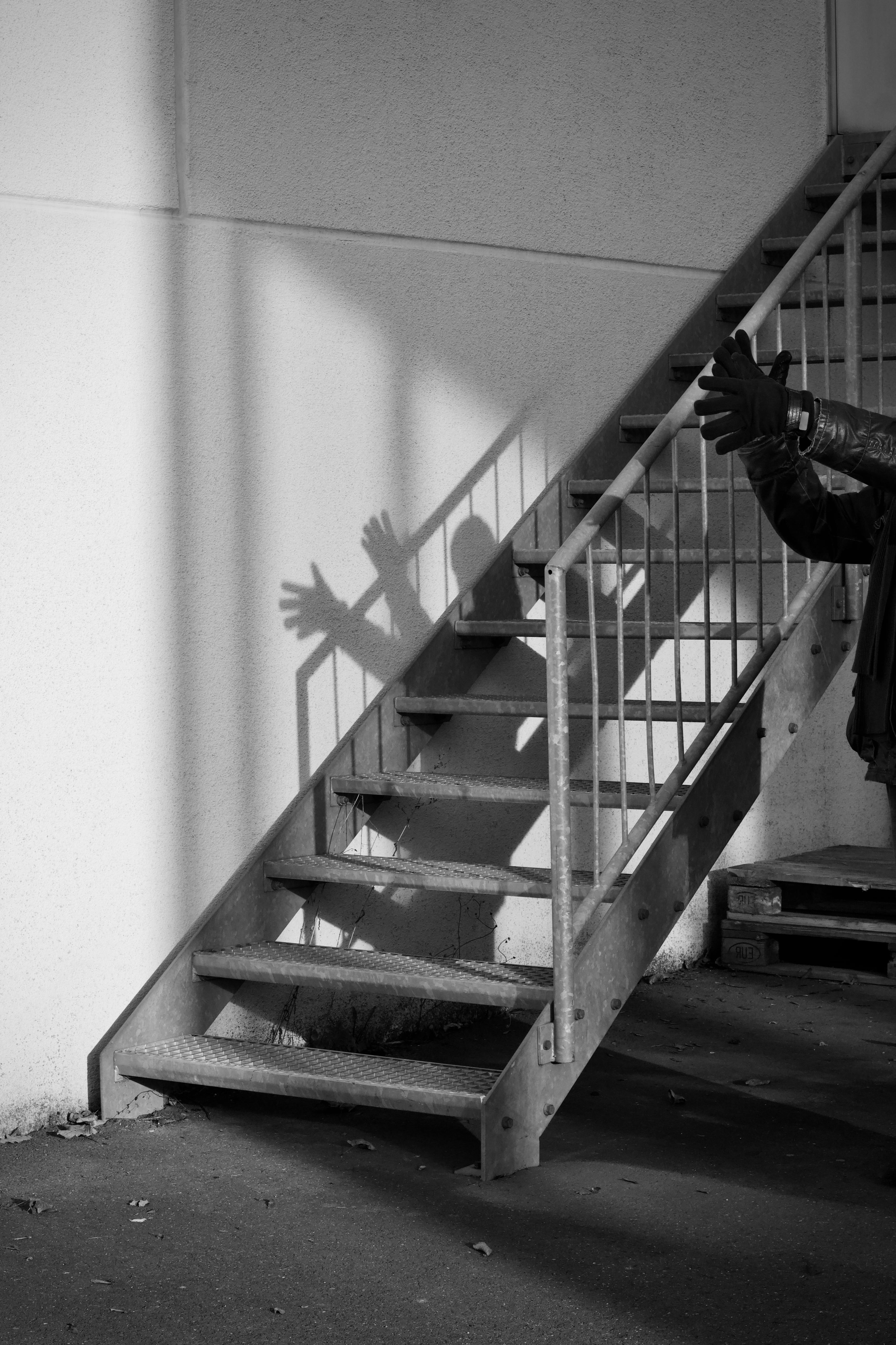 ingyenes Lépcsőre vetülő árnyékok művészi fekete-fehér képe kinyújtott kézzel. Stockfotó