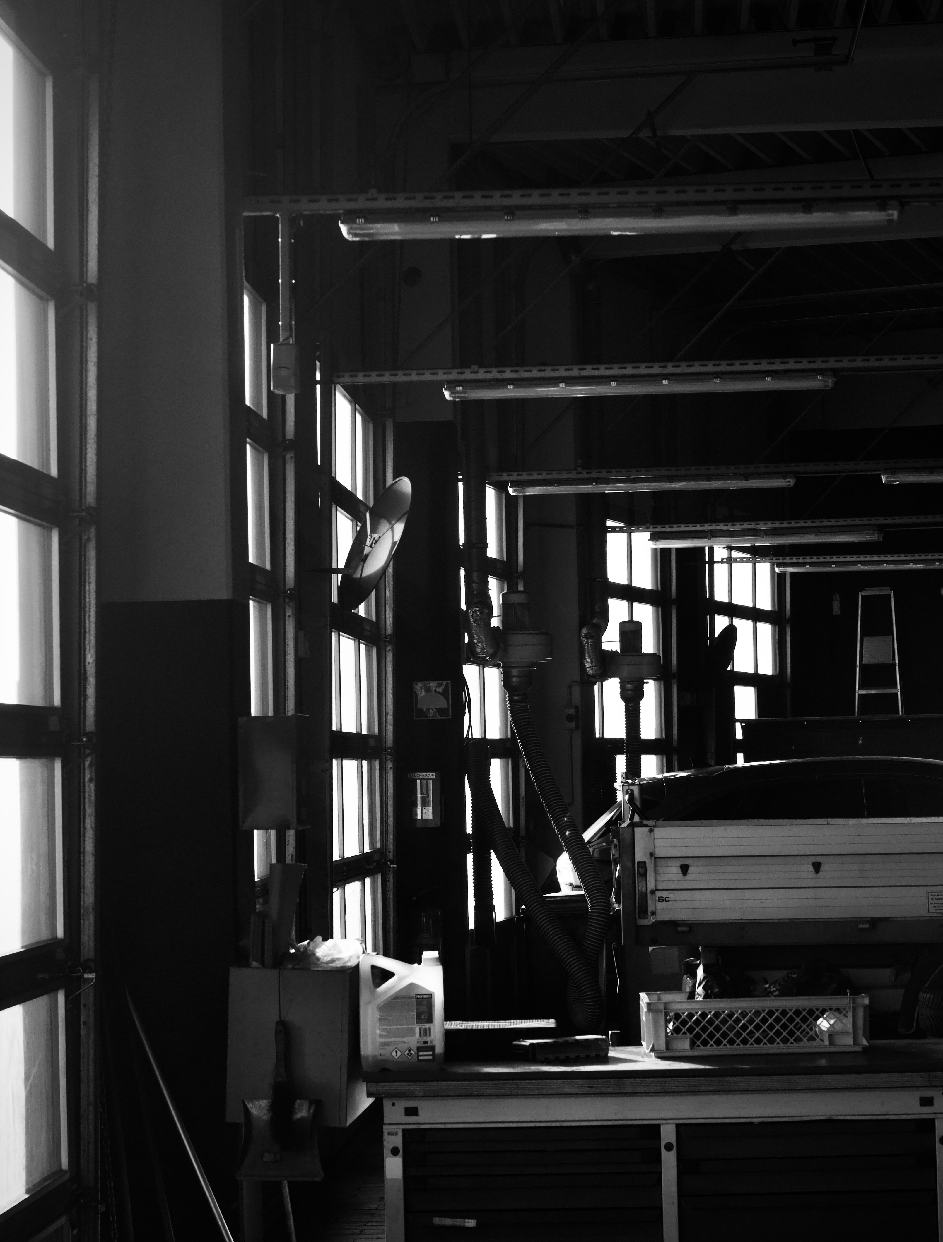 Monochrome image of a garage interior with tools and equipment, showcasing industrial design.