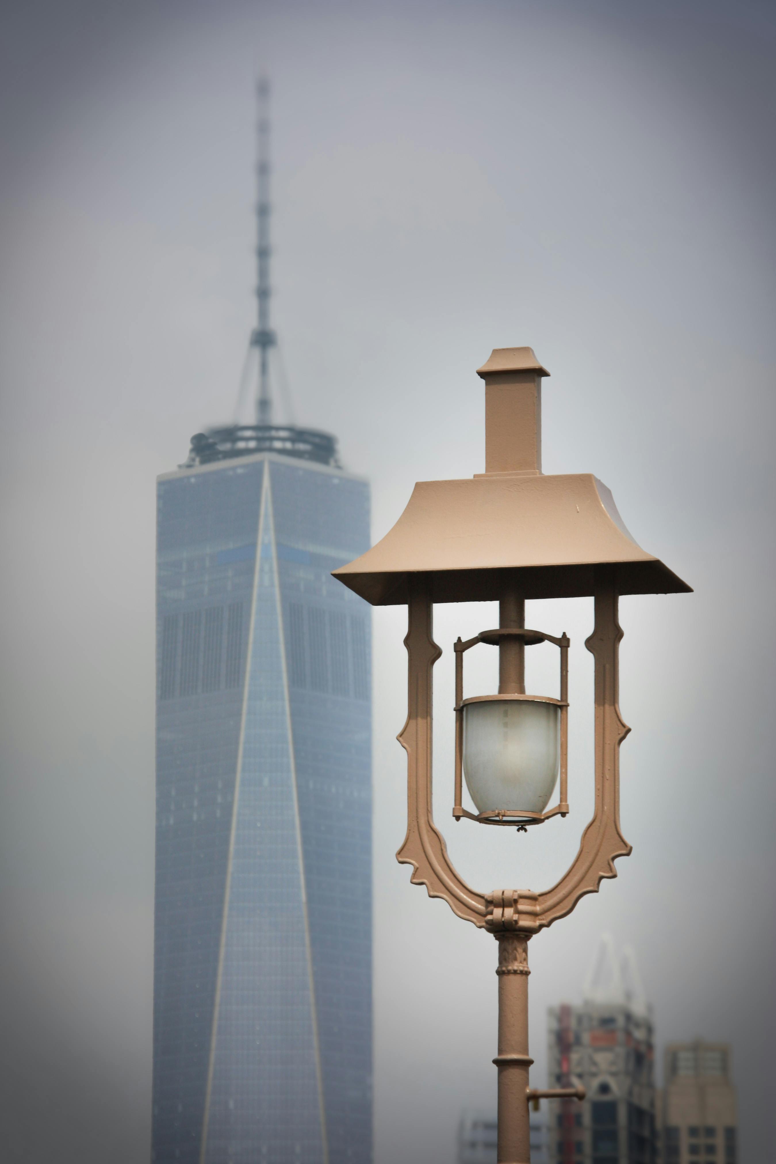 ฟรี โคมไฟถนนโดยมีตึกวันเวิลด์เทรดเซ็นเตอร์เป็นฉากหลัง ในวันที่ท้องฟ้ามีเมฆมากในนครนิวยอร์ก คลังภาพถ่าย