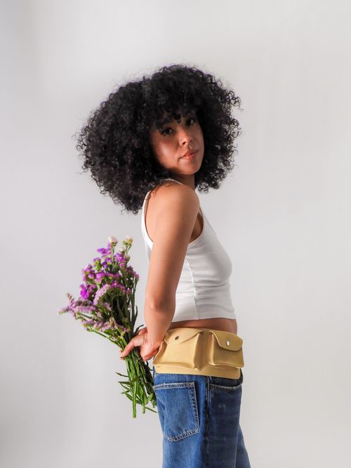 Free A young woman with curly hair holds a bouquet, exuding a casual vibe. Stock Photo