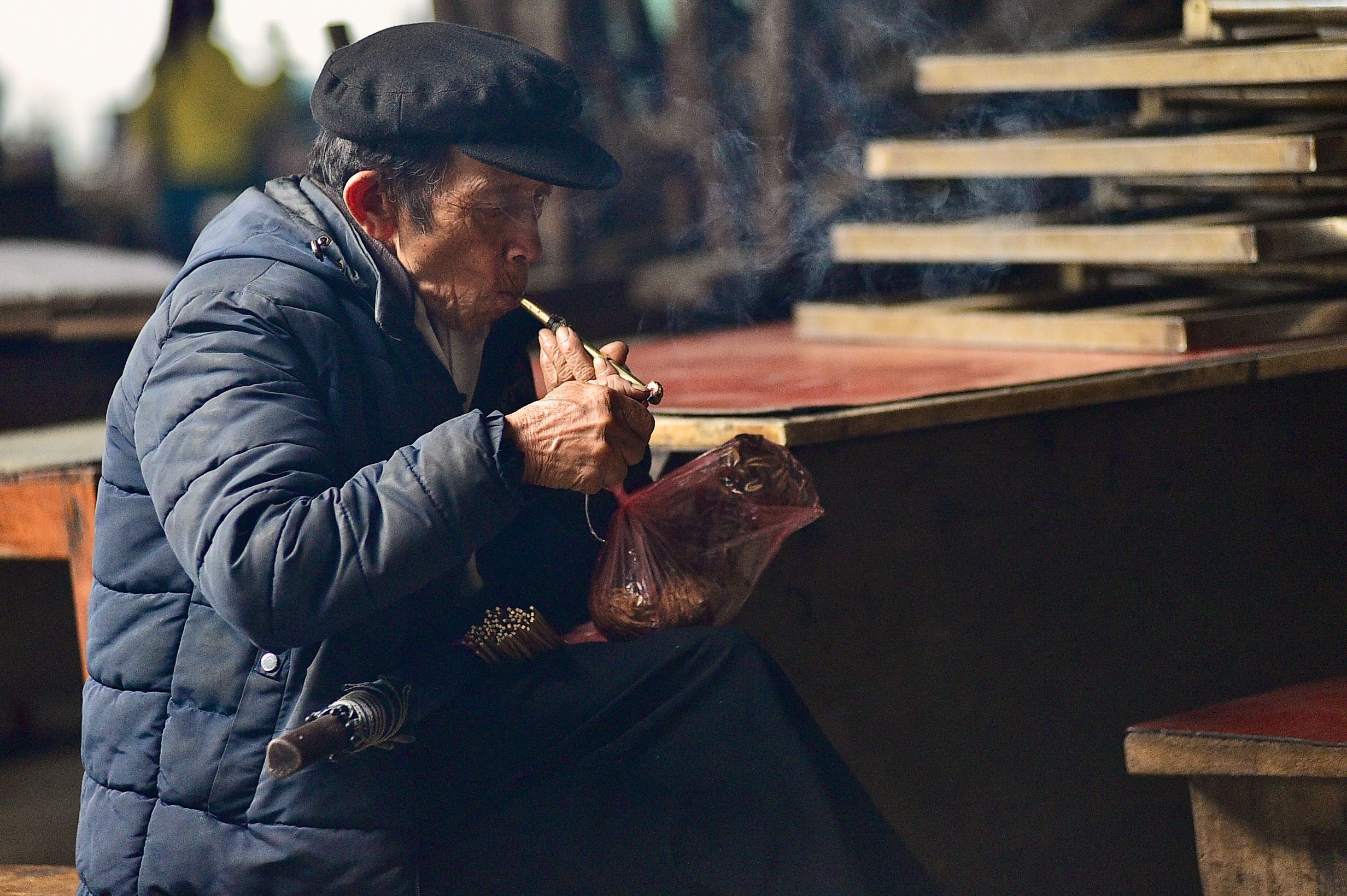 Elderly Man Smoking Pipe in Urban Setting · Free Stock Photo