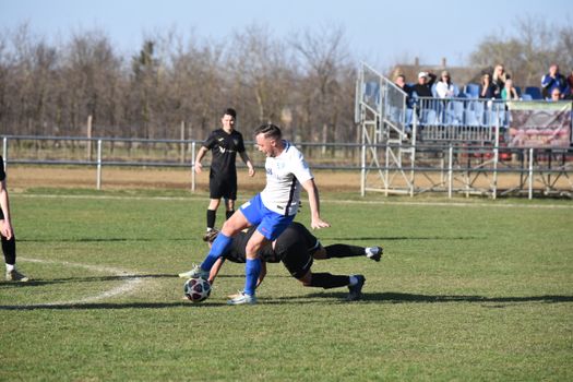 Players in action during a local soccer match in Vásárosnamény, Hungary, showcasing intense athletic competition.