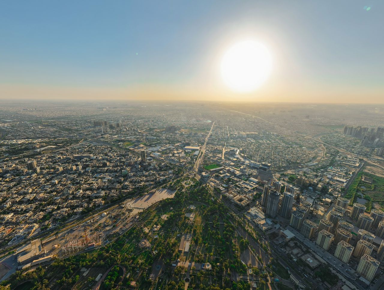 panoramic aerial view of a sprawling cityscape under a bright sunset s
