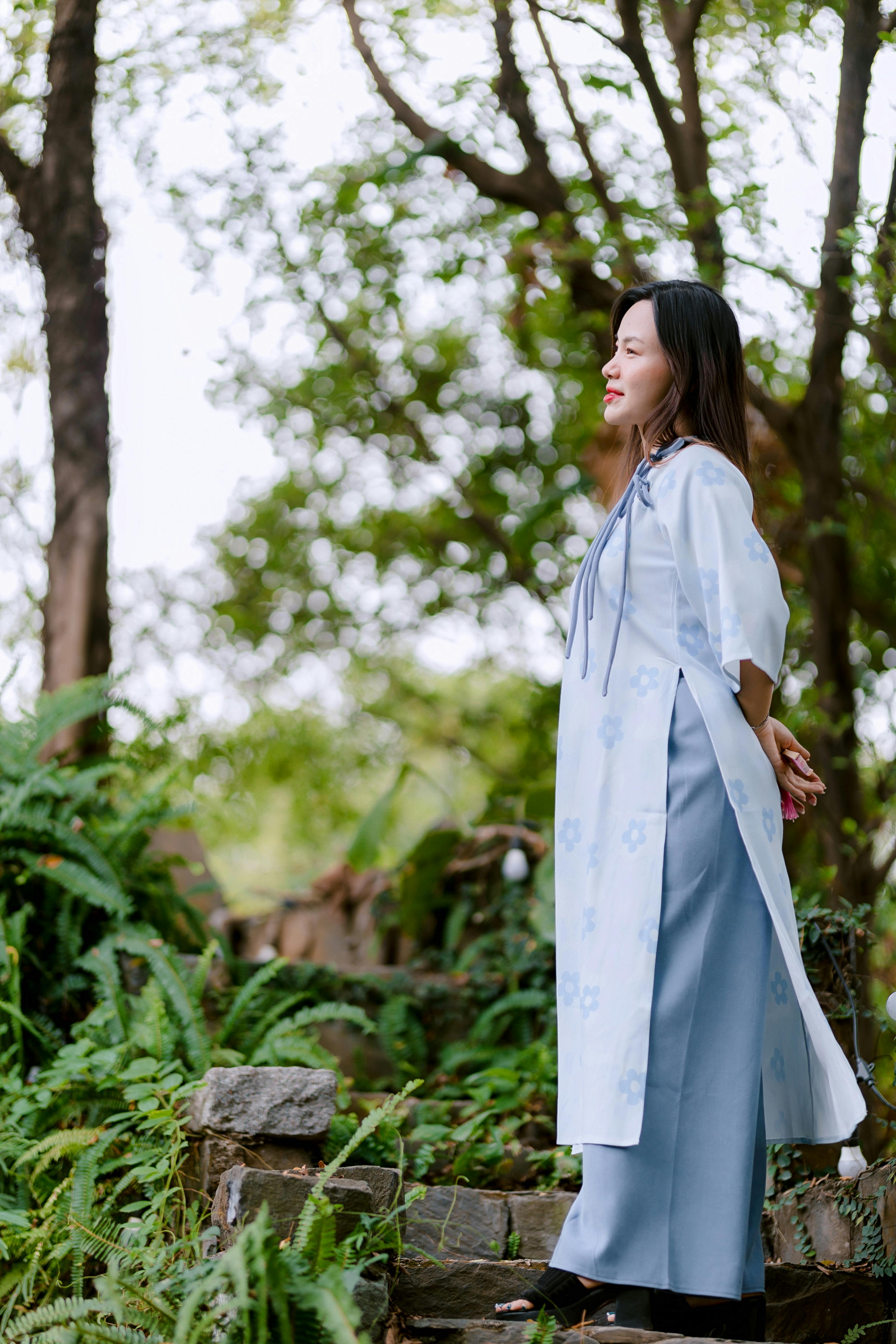 Kostnadsfria Kvinna i elegant traditionell klädsel uppskattar naturen utomhus på en fridfull dag. Stock foto