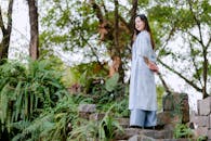 Woman in Traditional Dress Amidst Lush Greenery Outdoors