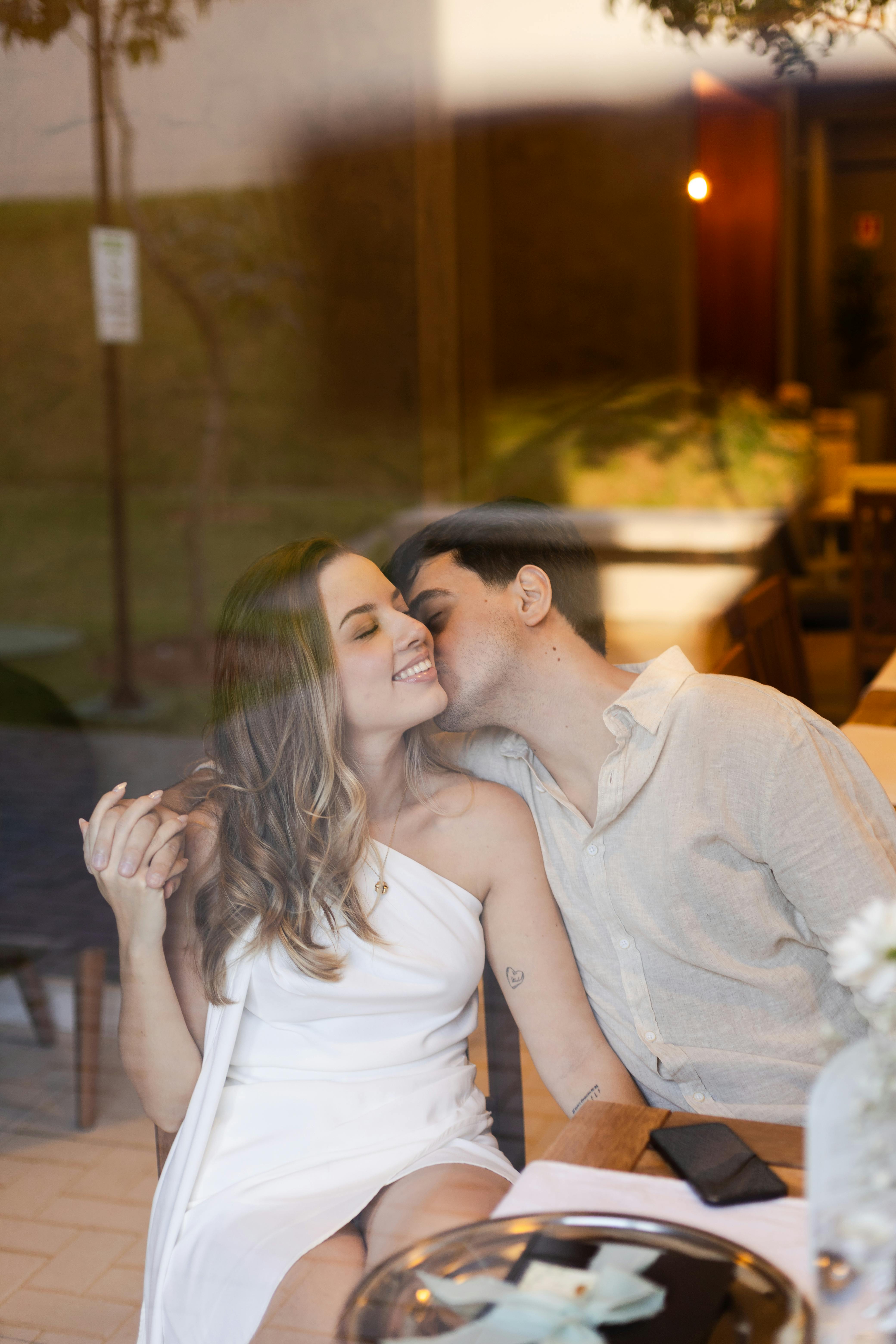 ฟรี คู่รักคู่หนึ่งแบ่งปันช่วงเวลาอันแสนหวานในร้านอาหารแห่งหนึ่งในเซาเปาโล แสดงให้เห็นถึงความรักและความใกล้ชิด คลังภาพถ่าย