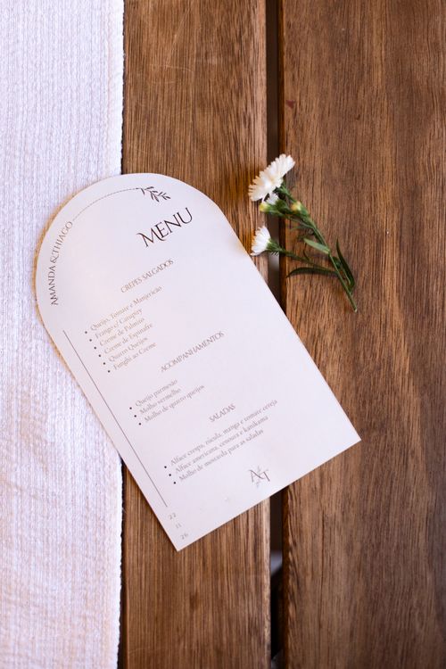 Free An elegant wedding menu placed on a rustic wooden table with a small flower decoration. Stock Photo