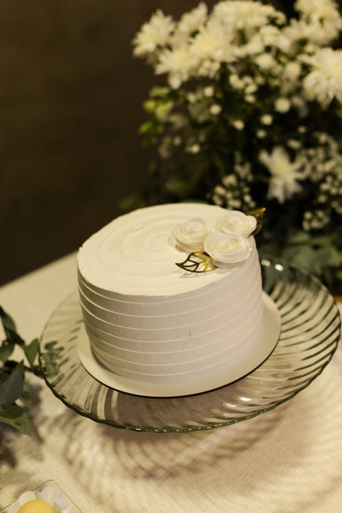 Free A beautifully decorated white wedding cake with roses, perfect for a sophisticated celebration. Stock Photo