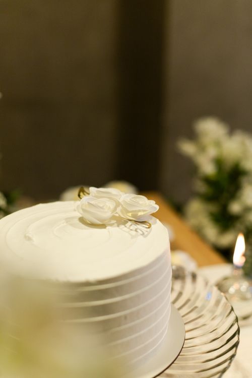 Free Elegant white wedding cake adorned with delicate floral decorations, perfect for a romantic celebration. Stock Photo
